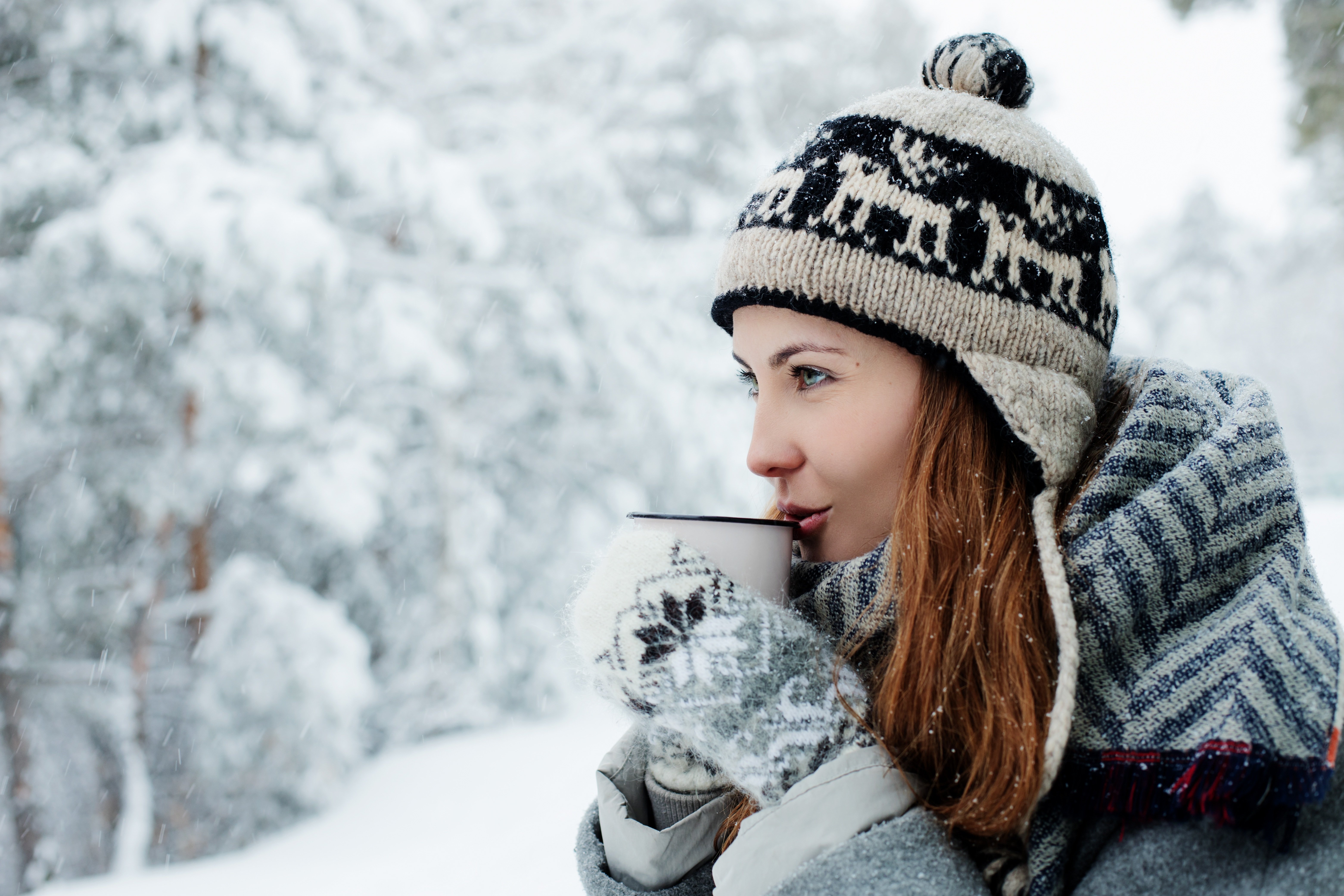 Beautiful girl in a warm hat drinks coffee in the winter on the street Desktop wallpaper 1024x1024