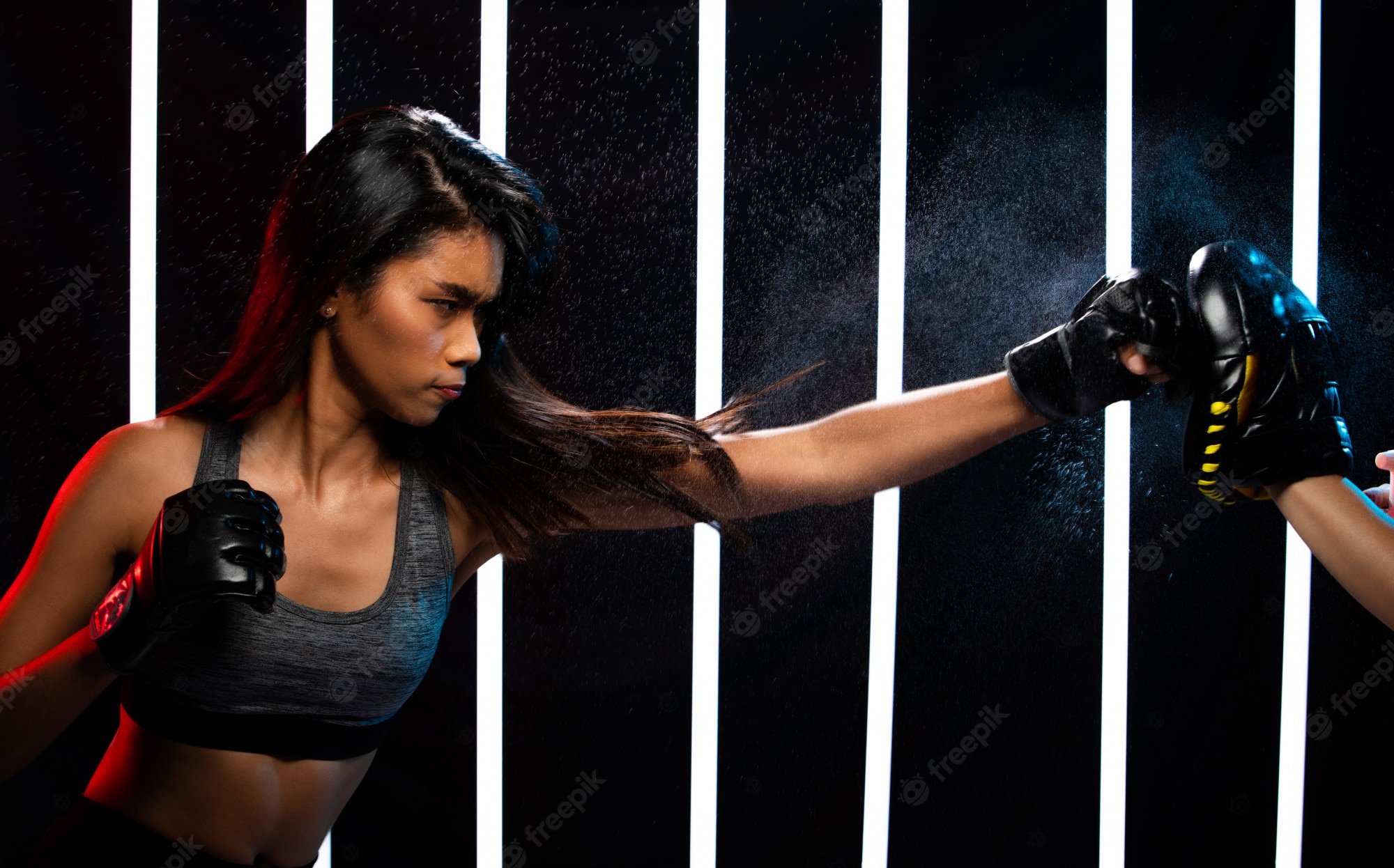 Premium Photo. Girl exercises in modern neon boxing gym heavily