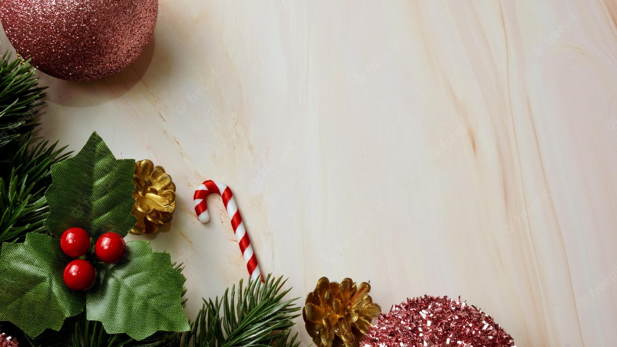 Premium Photo. Green pine tree leaves, pink christmas decorations and candy canes on soft marble background, christmas decorations in bright and fancy pink color. simple and creative christmas concept