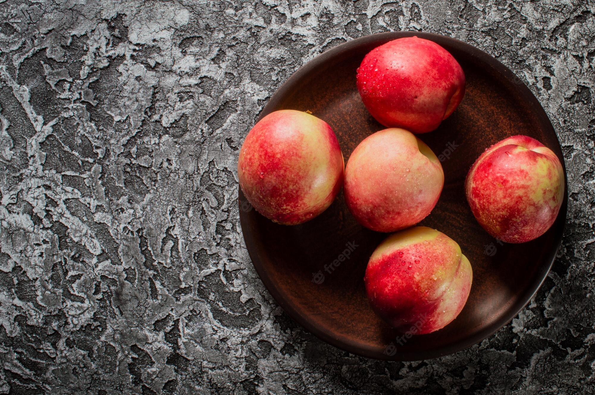 Premium Photo. Background of bright and ripe nectarines in full screen autumn wallpaper of exotic southern fruits the concept of harvesting