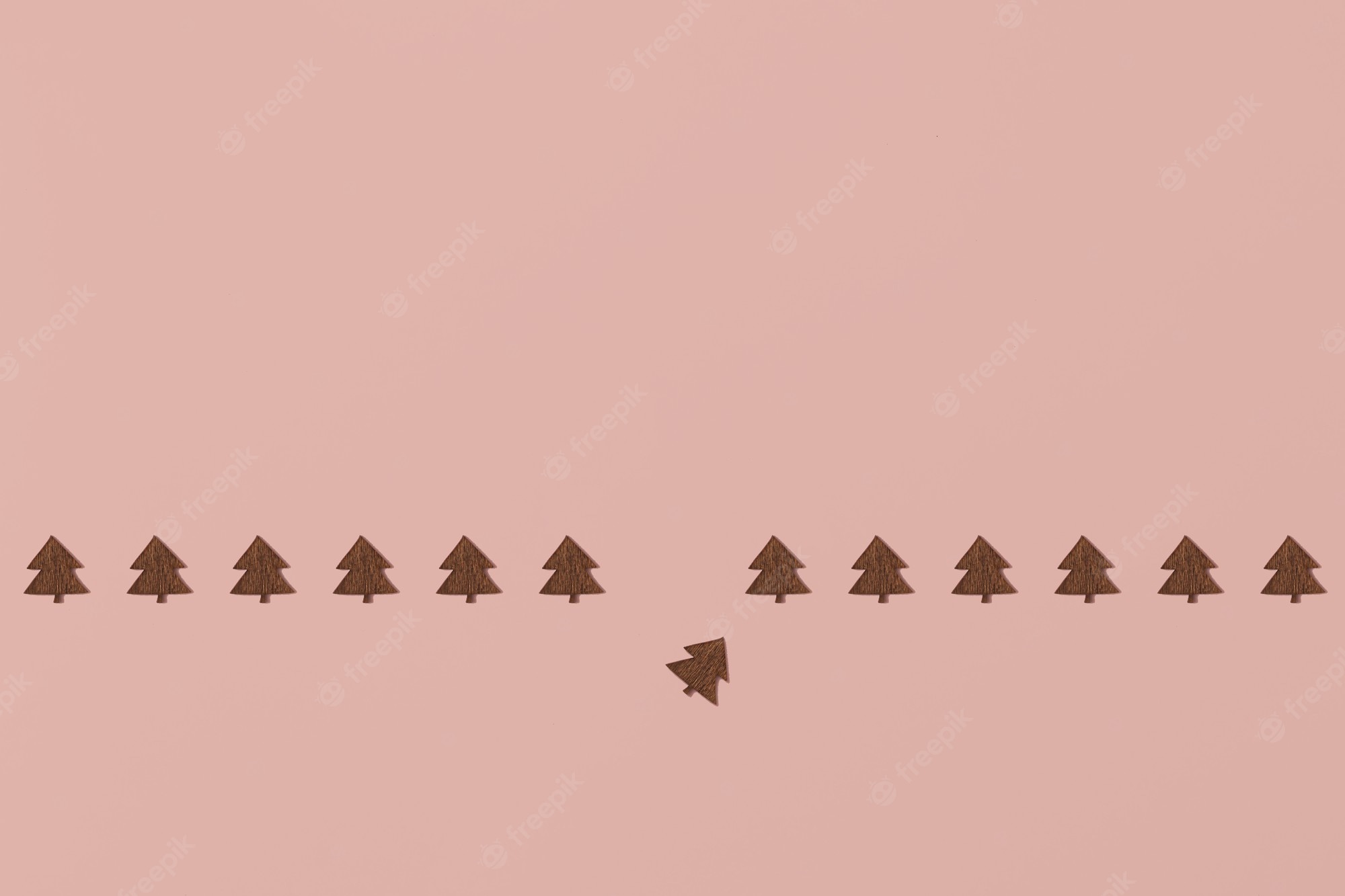 Premium Photo. Trendy creative christmas pattern made with wooden christmas trees on bright light pink background. minimal christmas concept with copy space