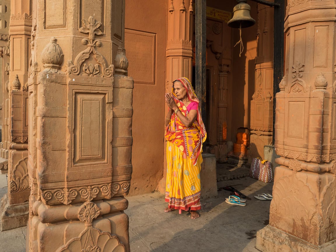 image By Abhishek. An old woman offers prayer, early in the morning in a temple at the ghats of Varanasi