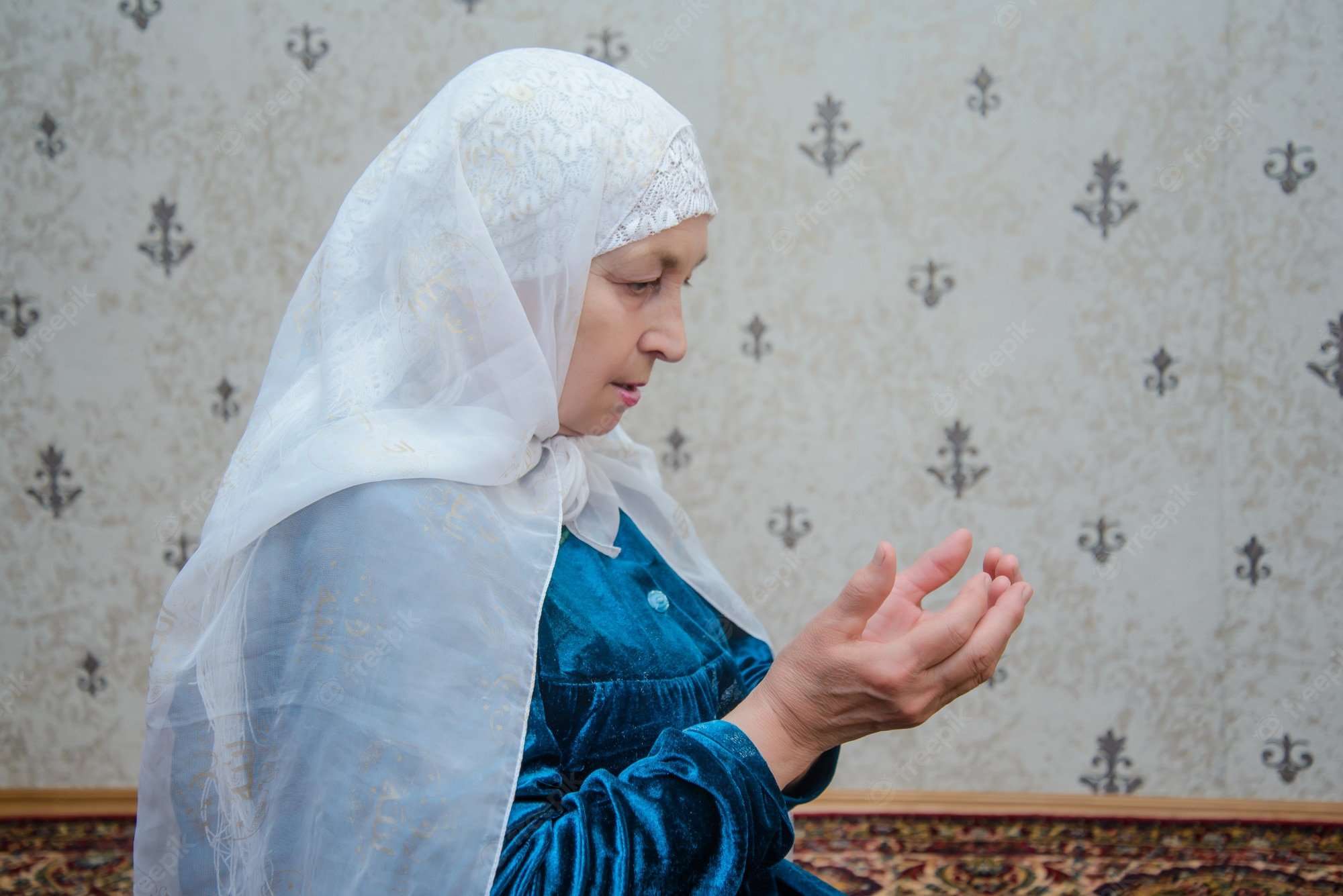 Premium Photo. An elderly muslim woman reads prayers