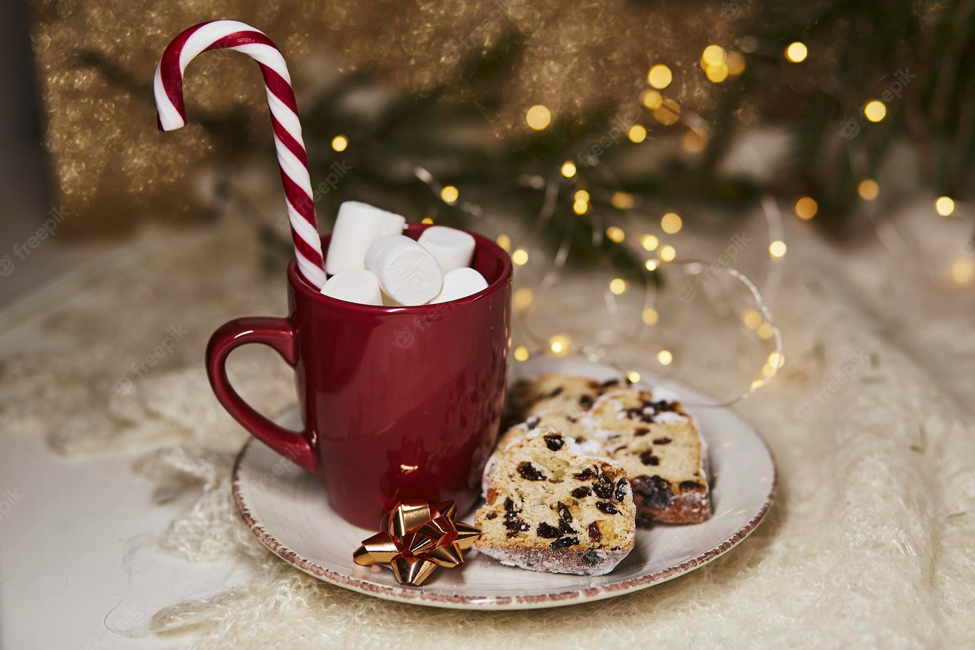 Premium Photo. Aesthetic hot beverage red cup with marshmallows and christmas stollen on ceramic plate traditional holidays bread candy cone stick festive christmas background christmas tradition food