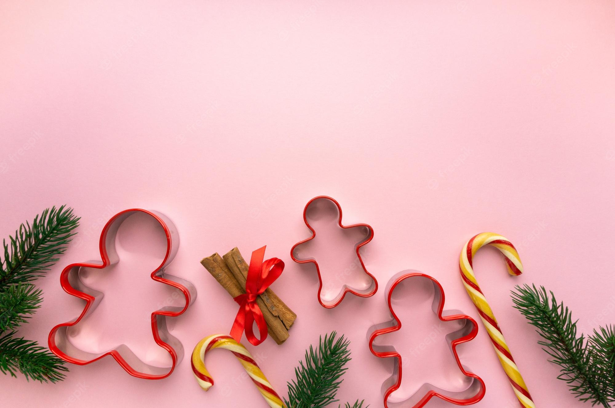 Premium Photo. Christmas cookie cutters in the shape of man on pink background, space for text
