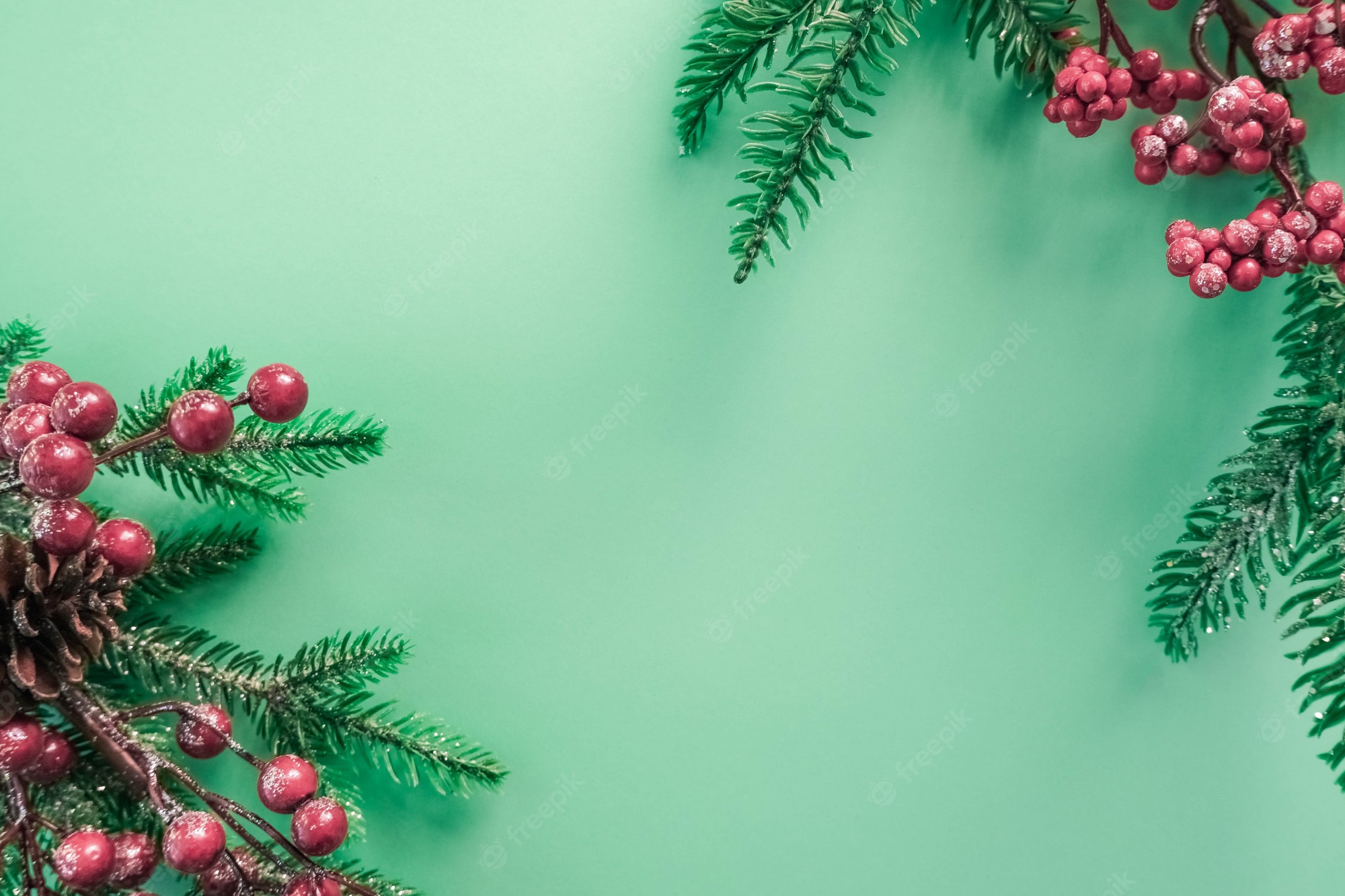 Premium Photo. Christmas decorations with red berries and fir branches on a beautiful mint background