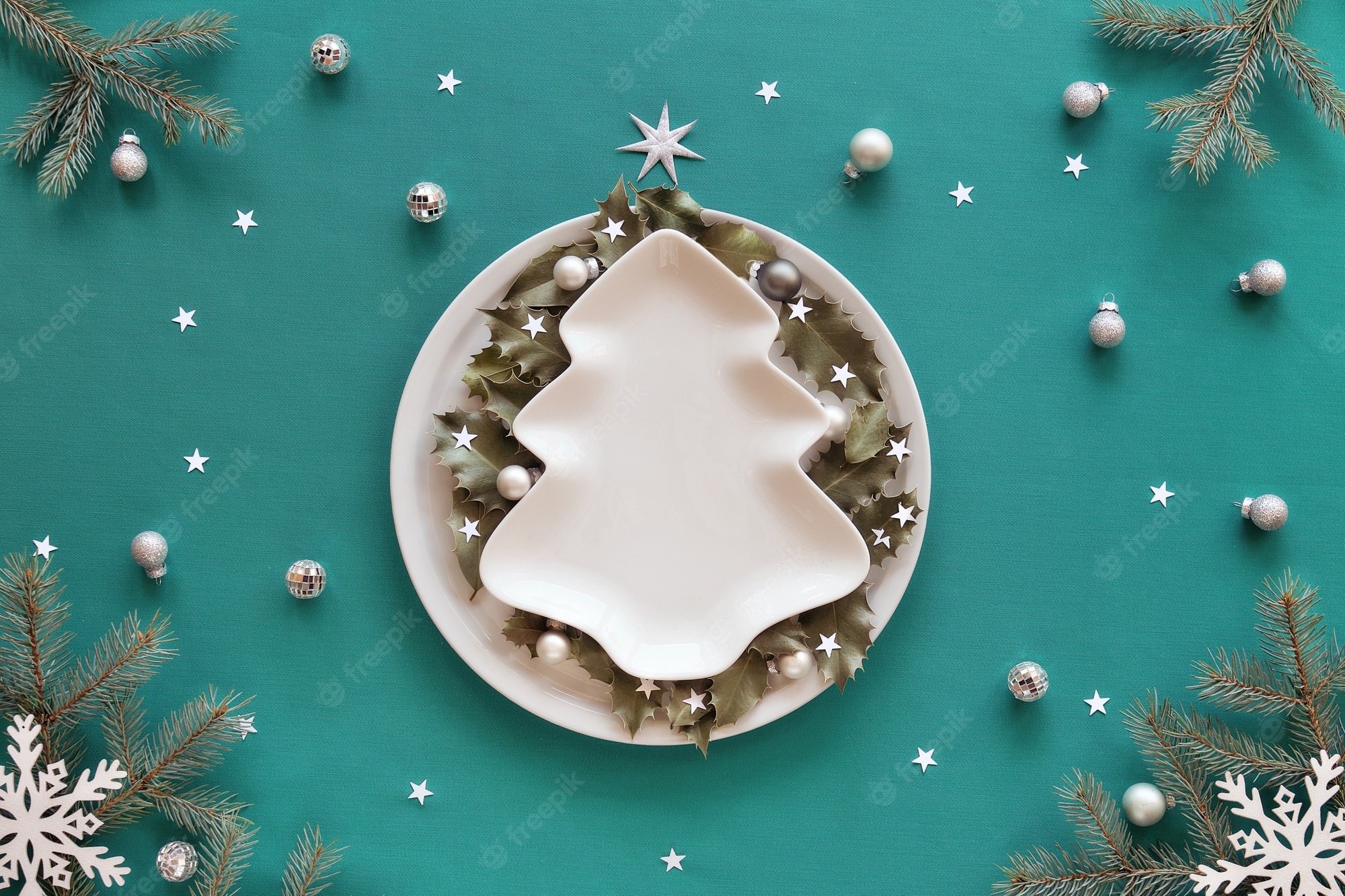 Premium Photo. Christmas Background In Green And White. Xmas Tree Shape Plate With Copy Space On Table Covered With Green Mint Textile. Fir Tree Twigs And White Decorations. Holly Leaves On Round