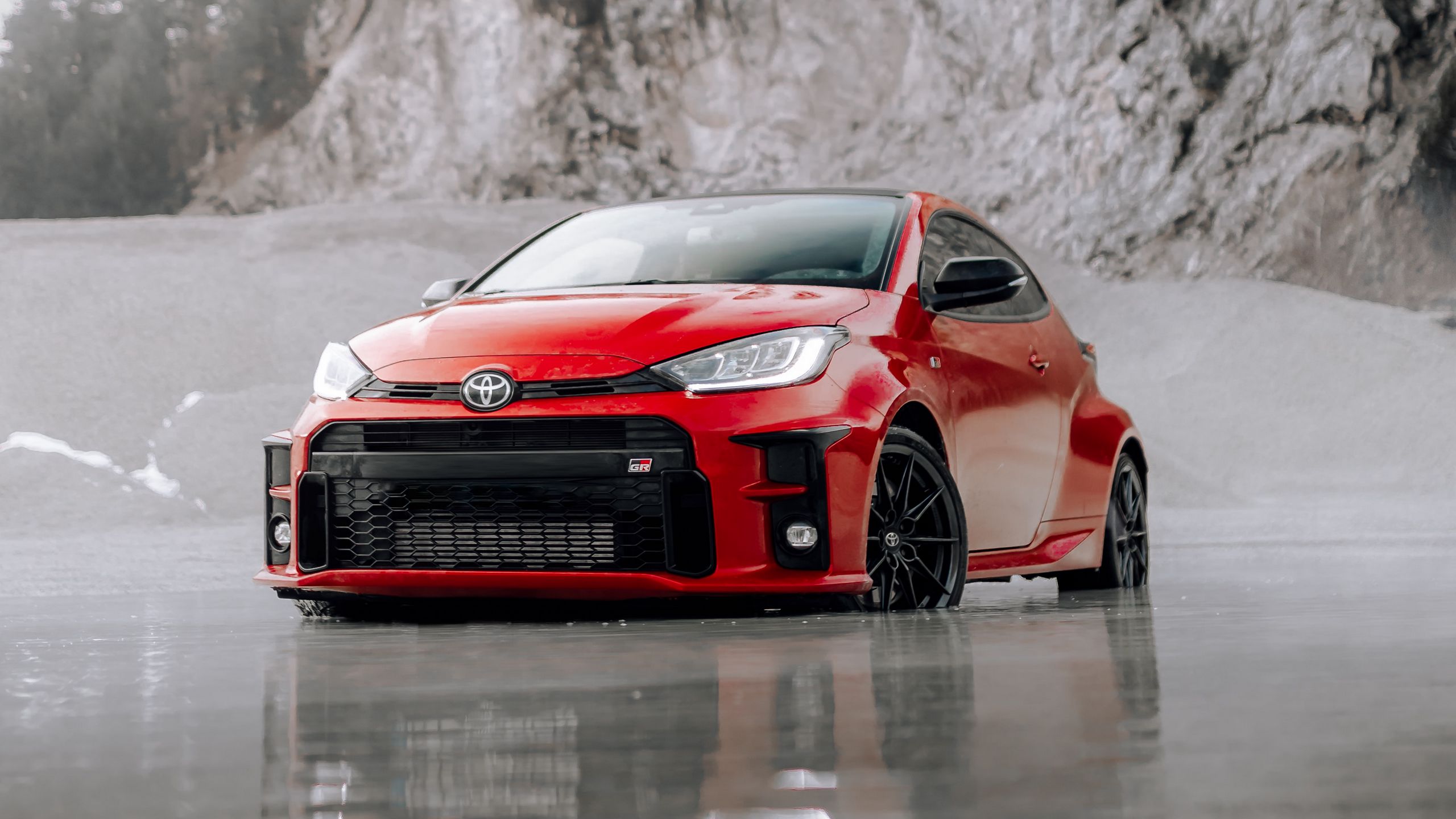 Download wallpaper 2560x1440 toyota gr yaris, toyota, car, red, front view, beach widescreen 16:9 HD background