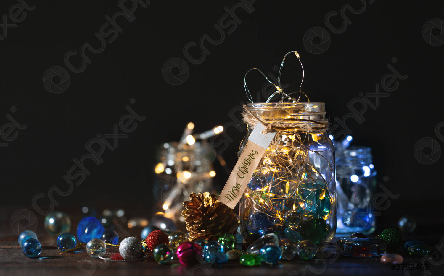 Glowing Christmas Lights and golden pine cone in a glass