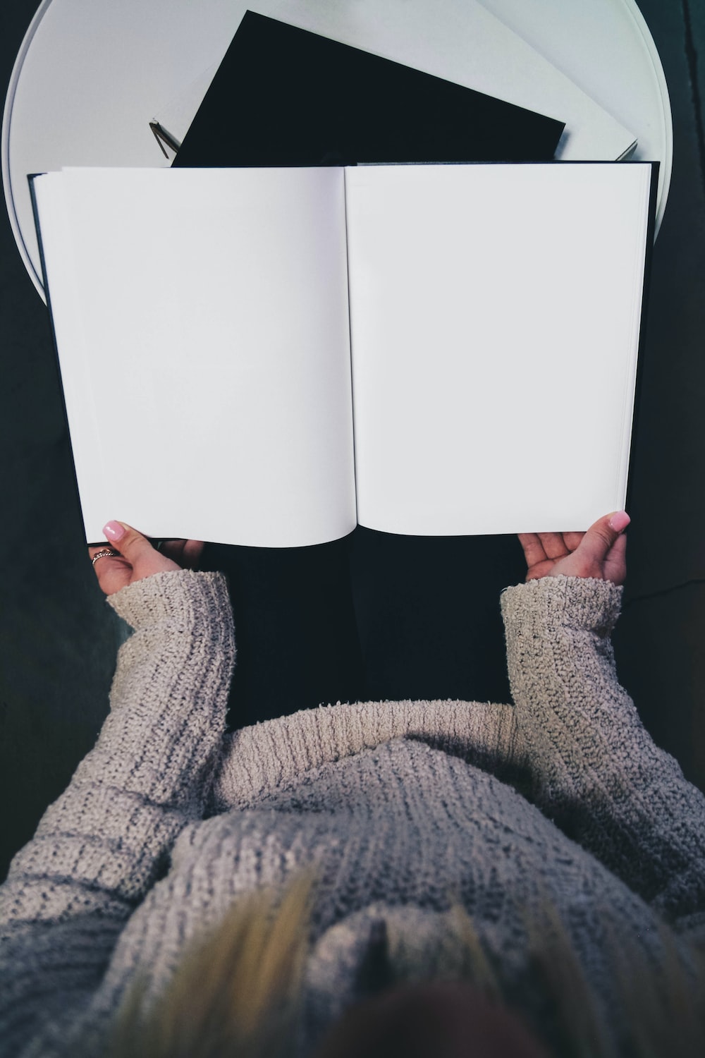 woman wearing sweater opening blank book photo