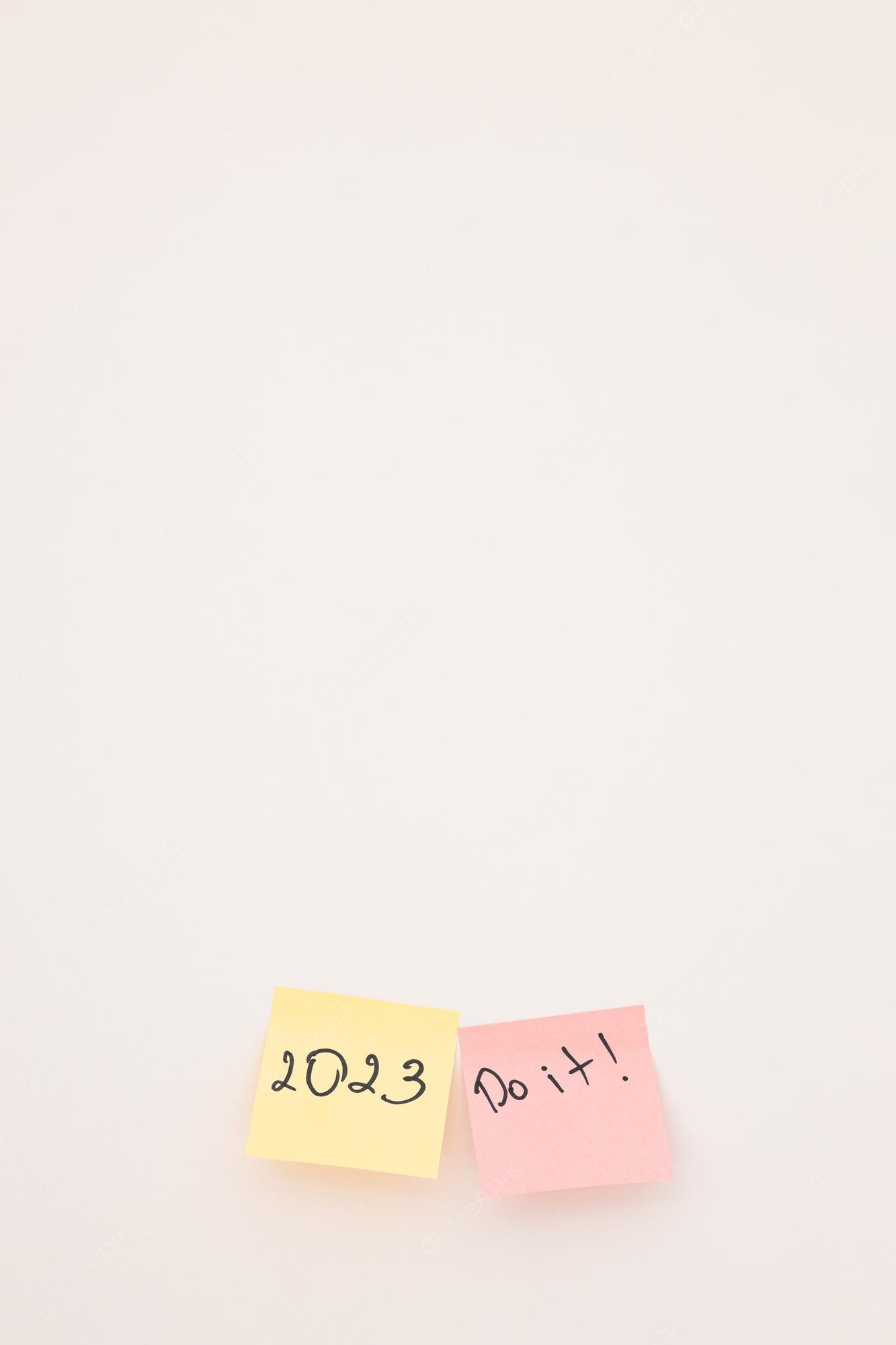Premium Photo. A sticky note with the year 2023 on white wall close up new year new chance