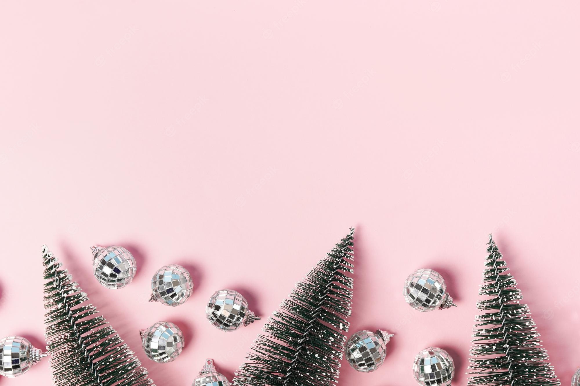 Premium Photo. Pink christmas card with fir trees and disco balls. christmas wallpaper. flat lay, copy space