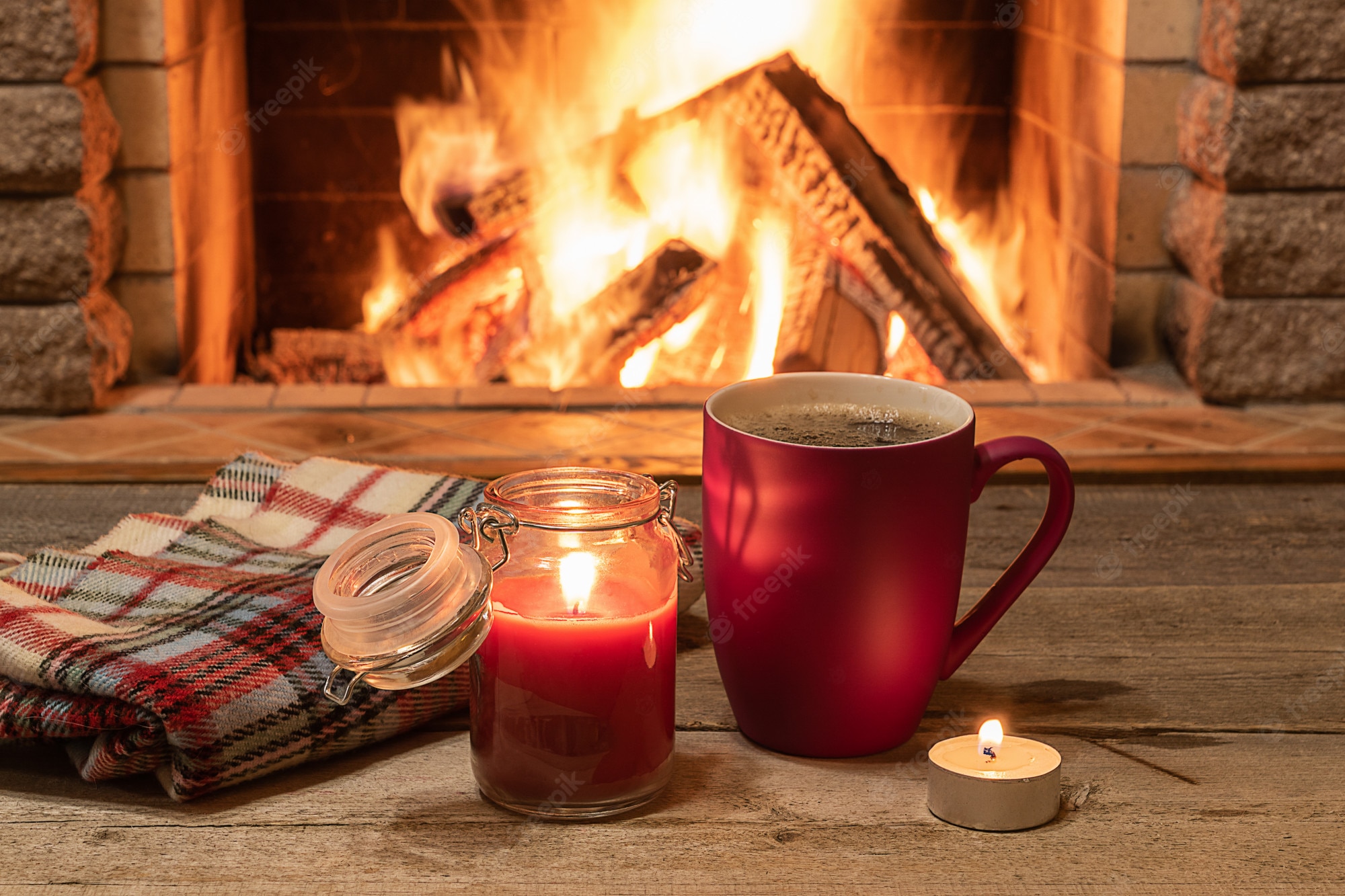 Premium Photo. Cozy scene near fireplace with mug of hot tea, warm scarf and candle