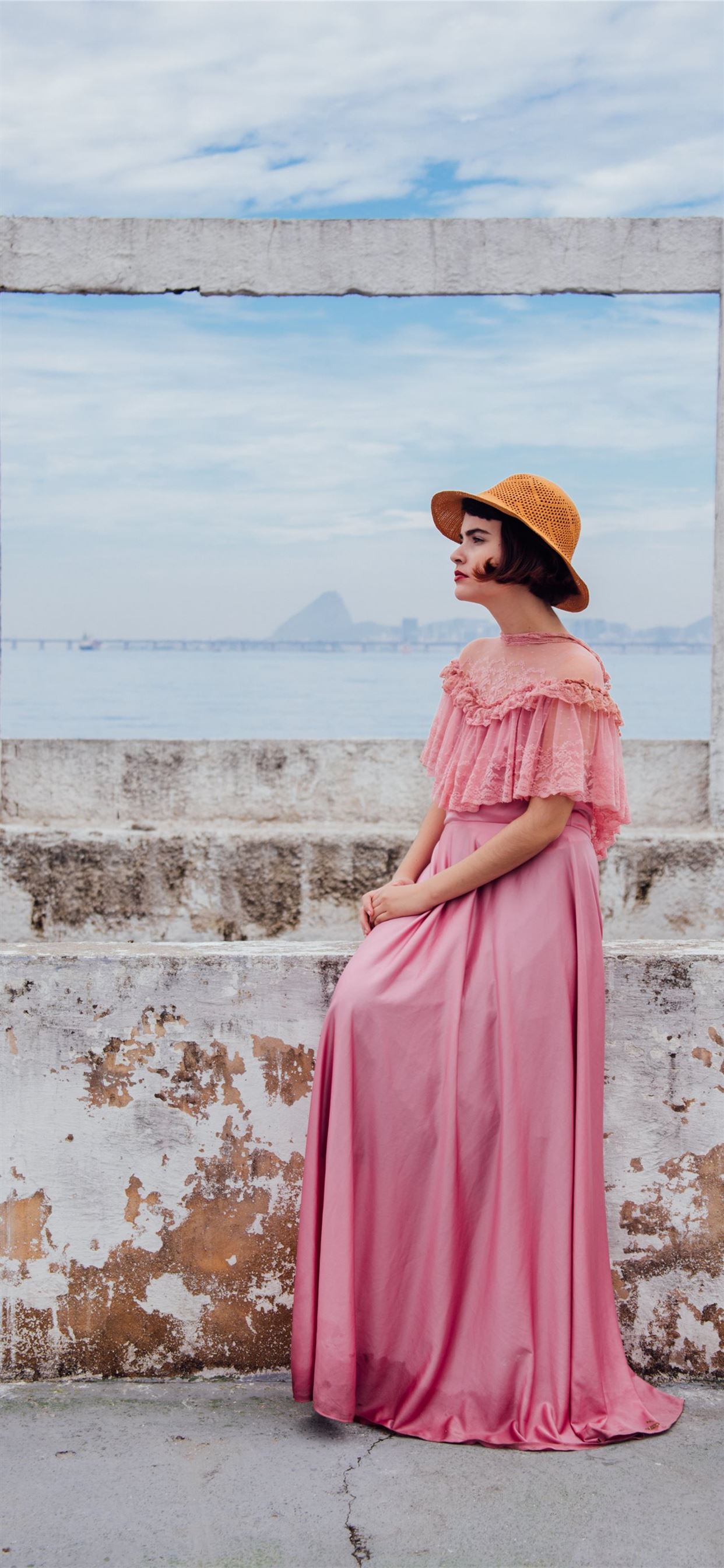 woman wearing pink dress standing next to white wa. iPhone 11 Wallpaper Free Download