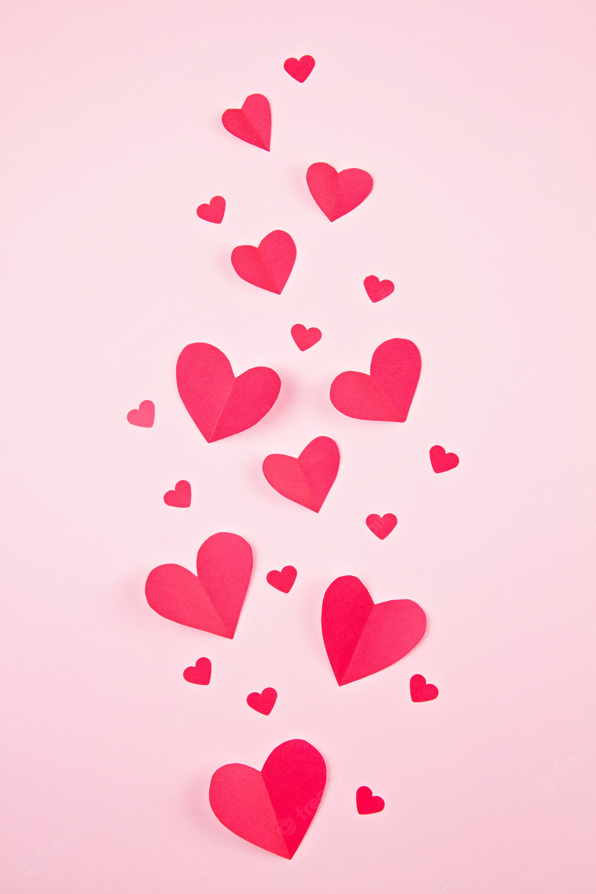 Premium Photo. Paper hearts over the pink pastel background. abstract background with paper cut shapes. sainte valentine, mother's day, birthday greeting cards, invitation, celebration concept