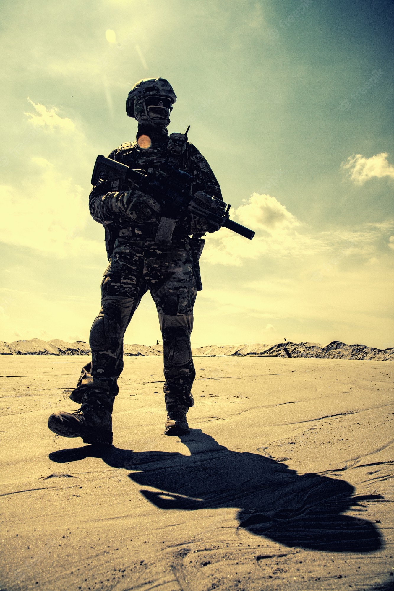 Premium Photo. Special operations forces soldier in camouflage combat uniform, helmet and glasses walking in desert with service rifle in hands low angle view. war conflict, military campaign in middle east