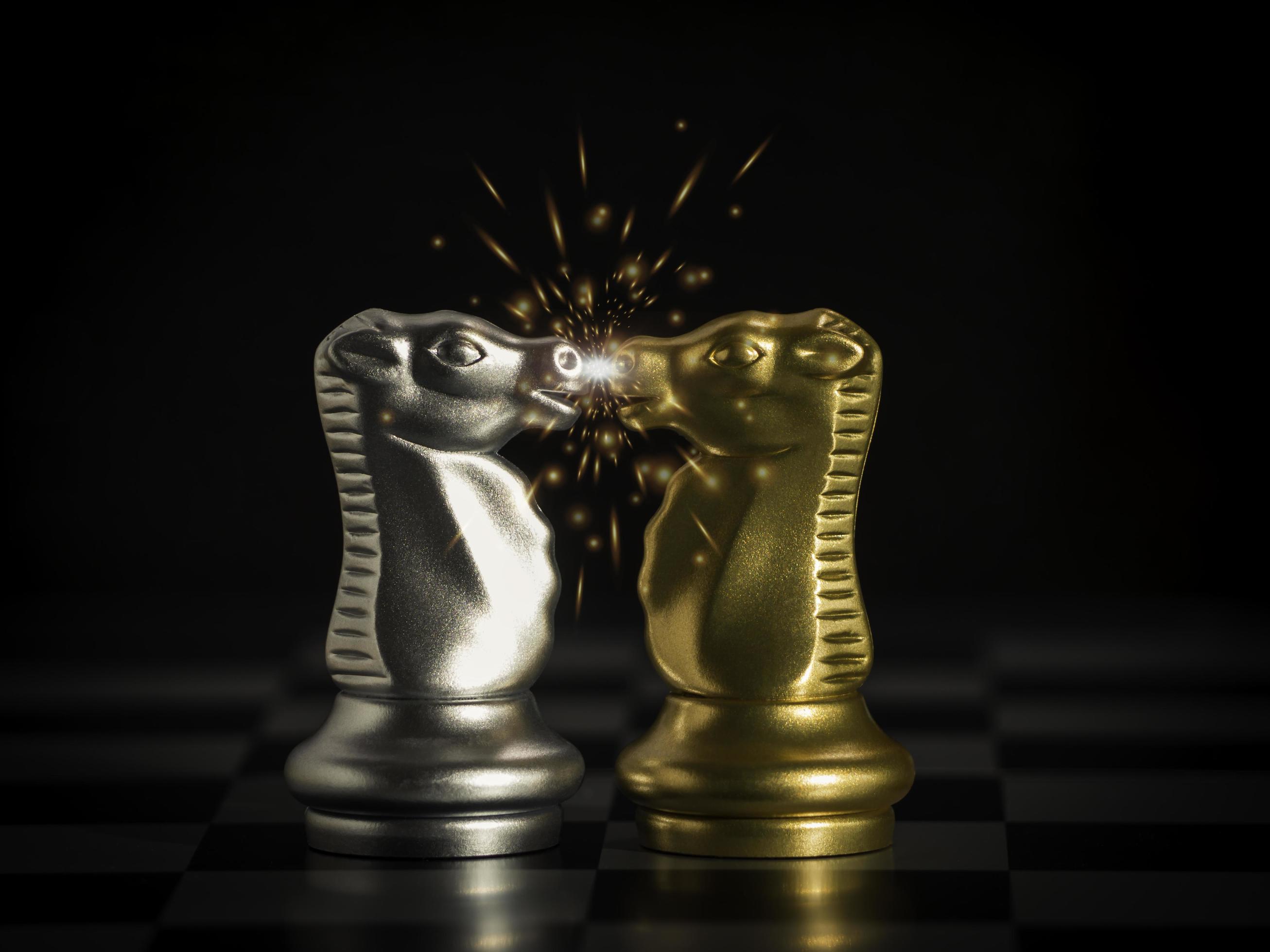 Gold knight chess facing silver knight chess with red hot flying sparks fire on chess board. Business leader market target strategy. business competition success, strategy ideas