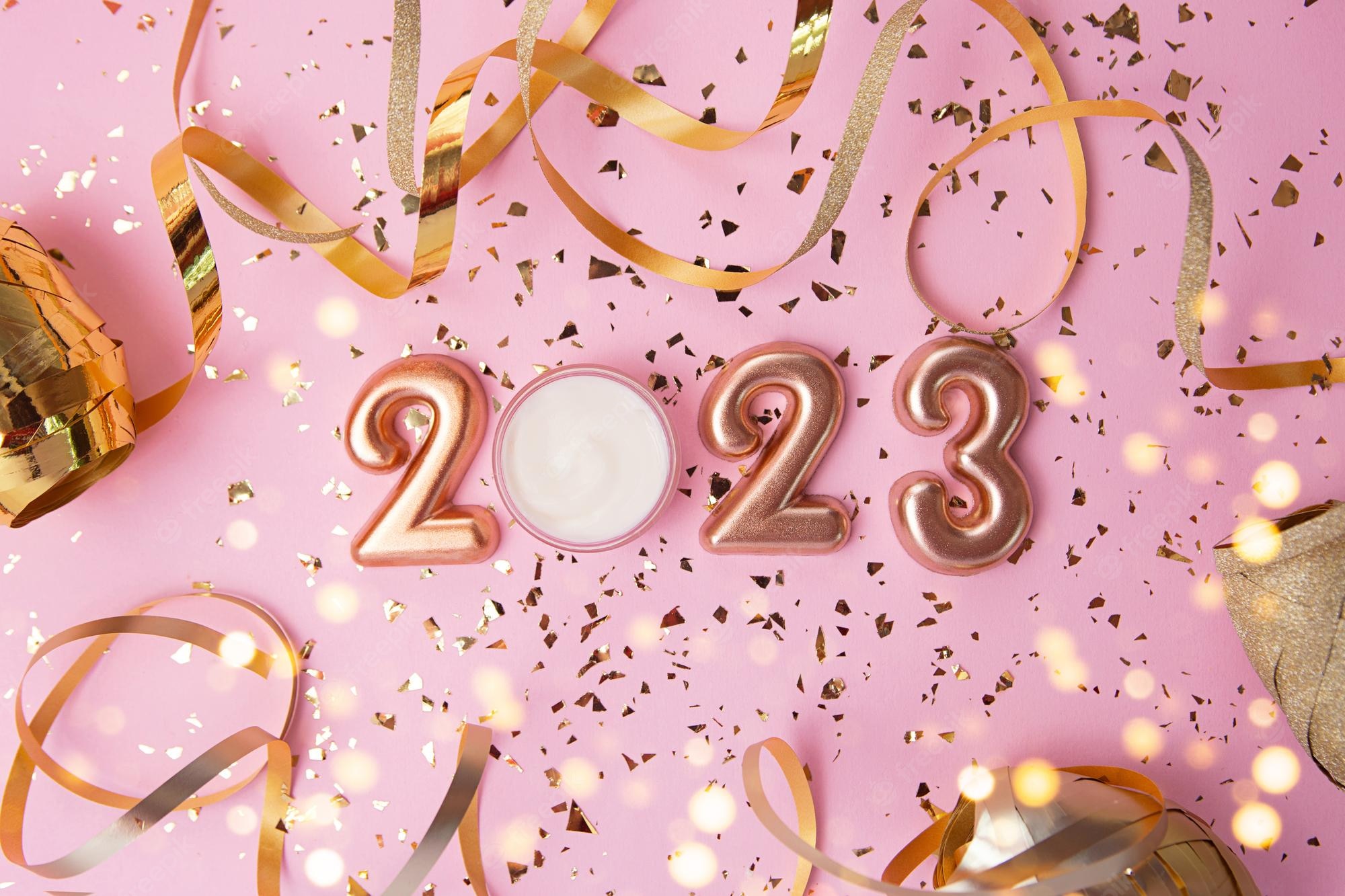 Premium Photo. Top view of rose gold numbers 2023 and face cream from above good for new year offer