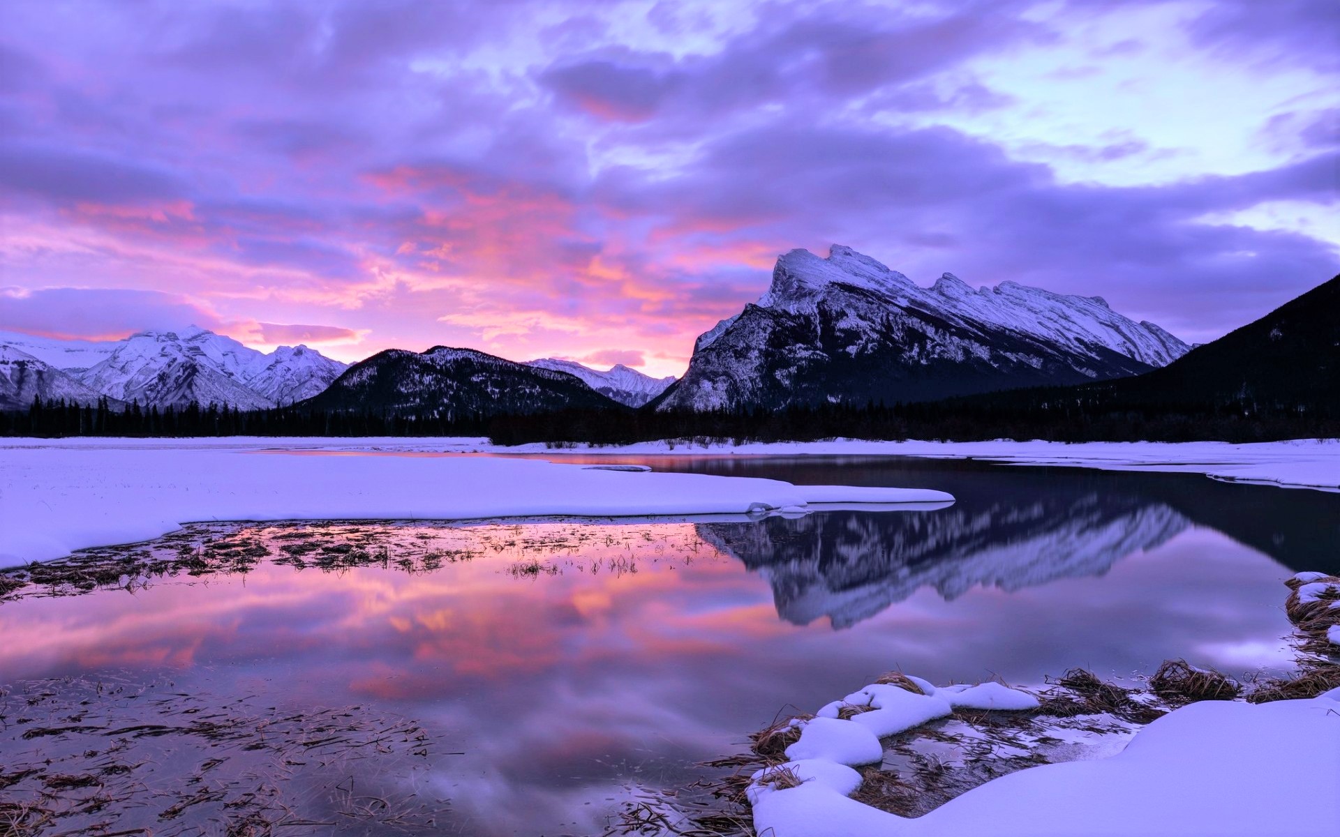 Pink Sunset and Clouds over Winter Mountain and Lake
