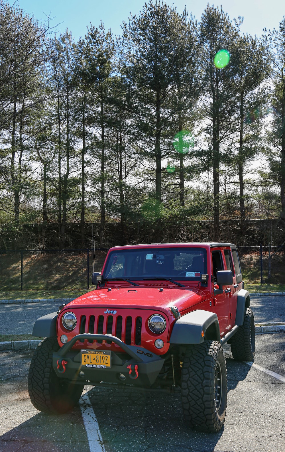 red jeep wrangler on forest during daytime photo