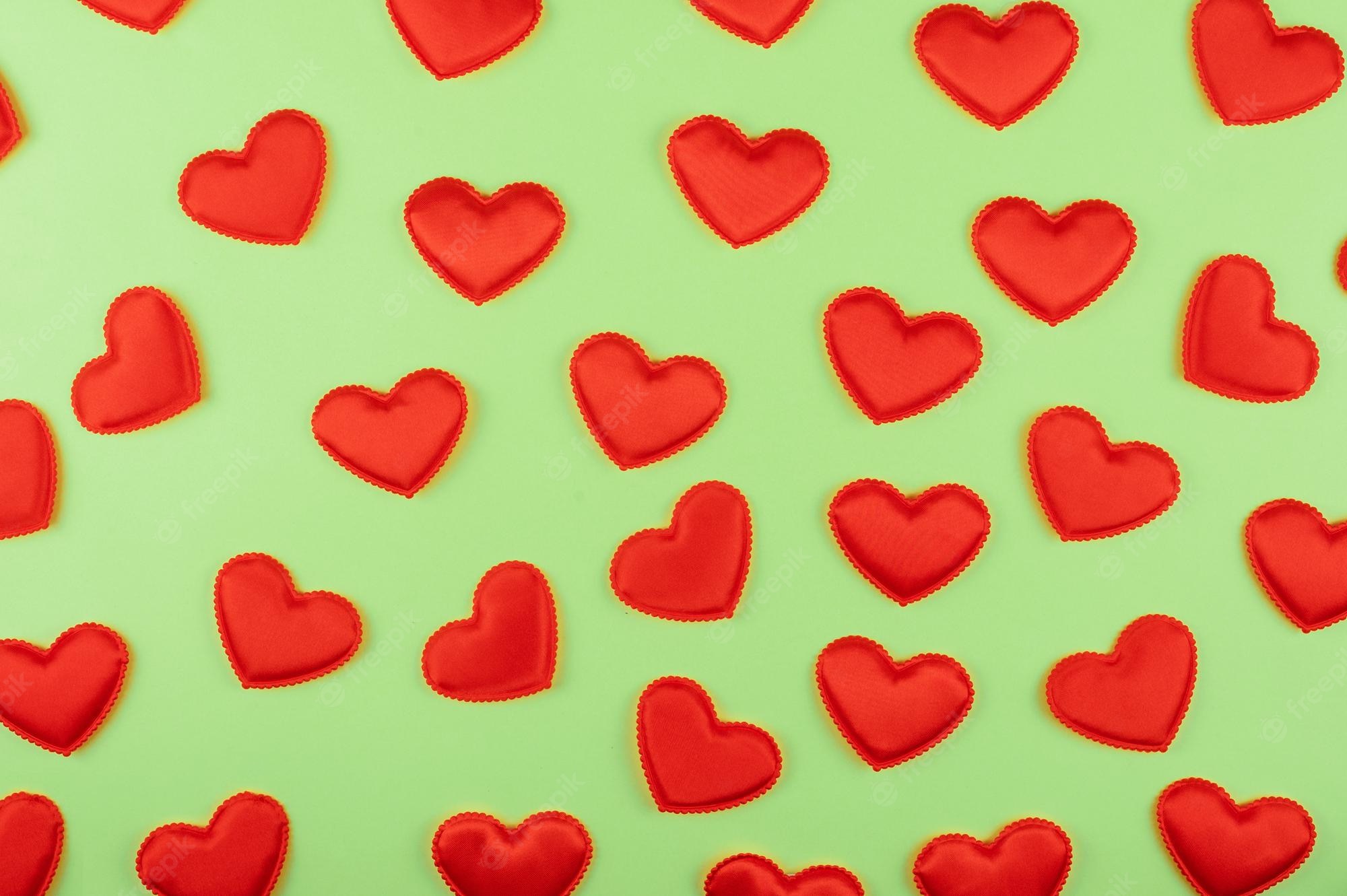 Premium Photo. Valentine day green paper background with red hearts background valentines day or love concept