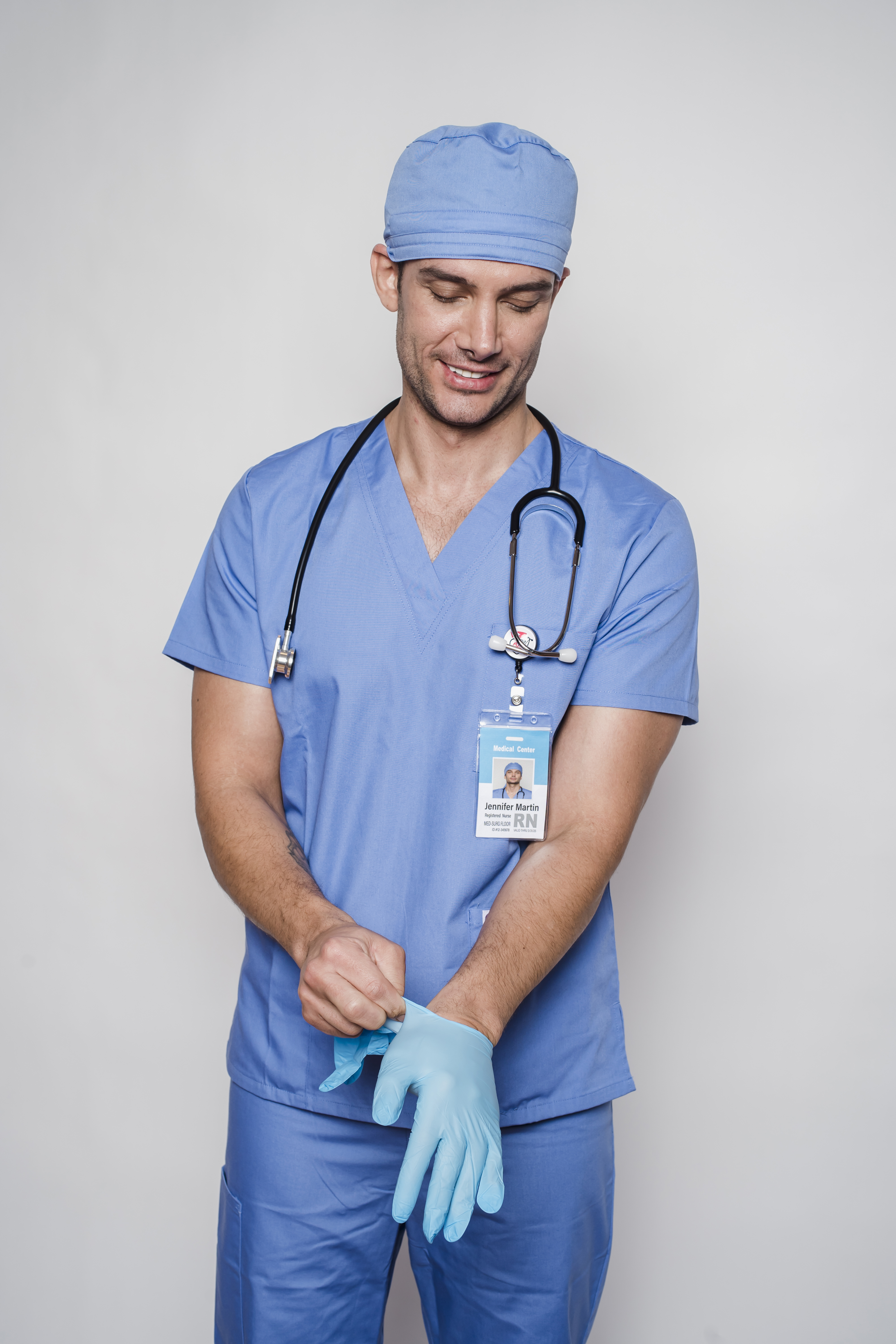 Male doctor in uniform putting on sterile gloves · Free
