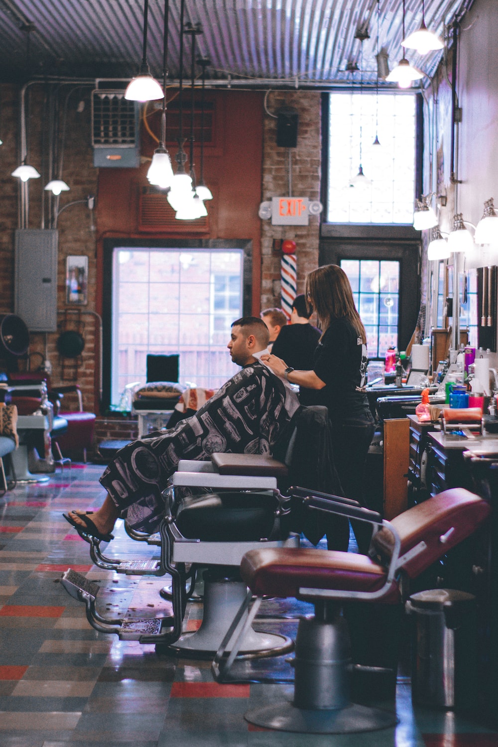 man standing beside man sitting on barber chair photo