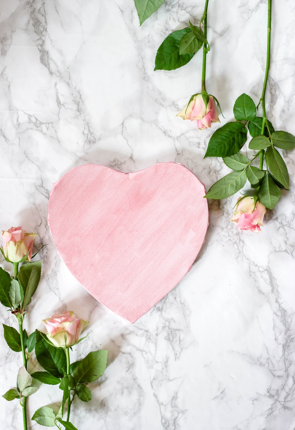 pink heart shaped paper on white and pink floral textile photo