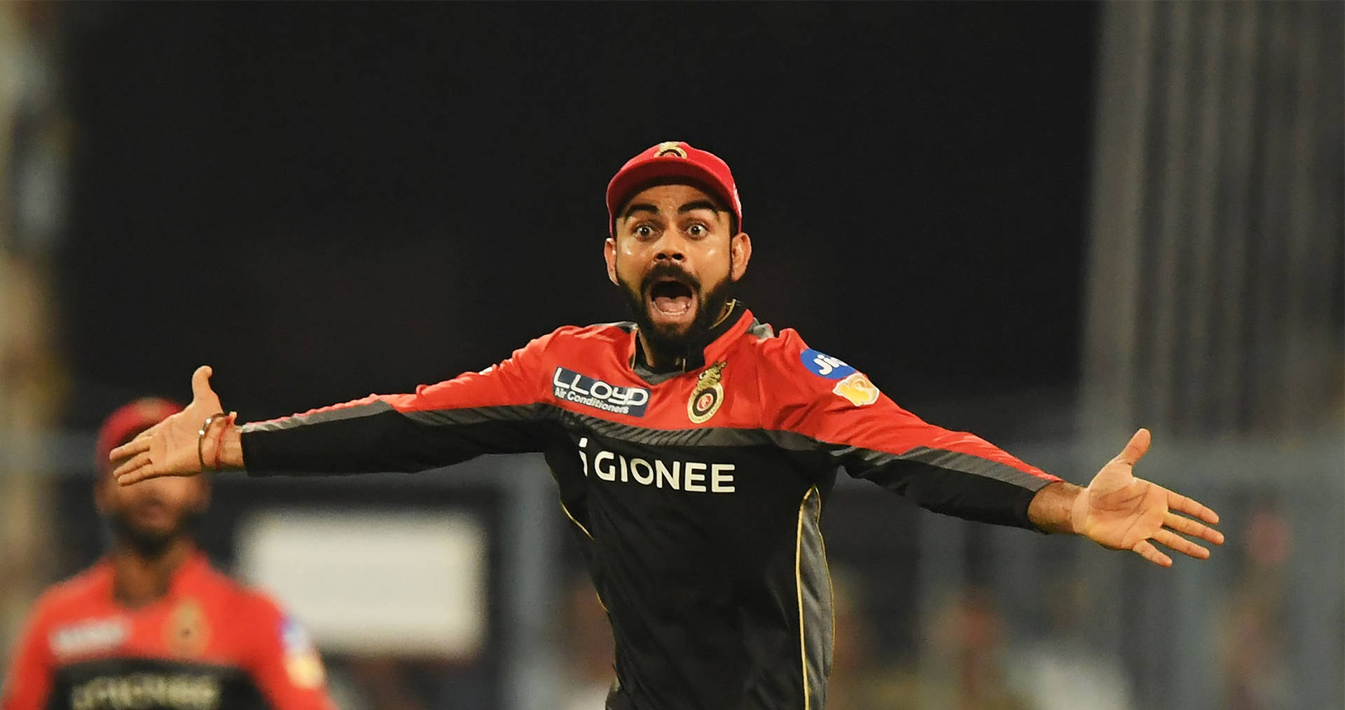 Download Rcb Team Kohli Arms Outstretched Wallpaper