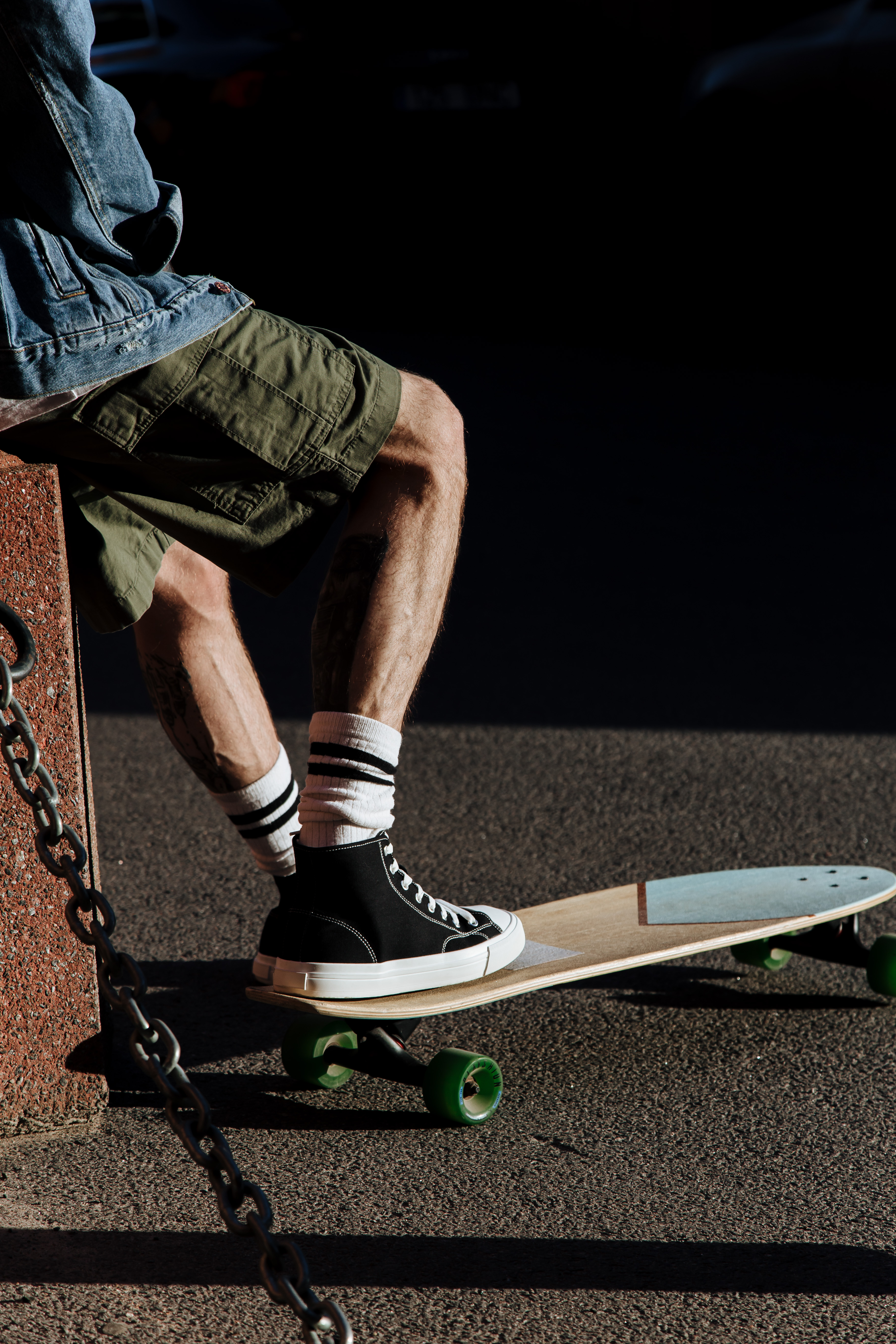 Unrecognizable Adult Male Legs in Shorts and Converse Stepping on Skateboard · Free