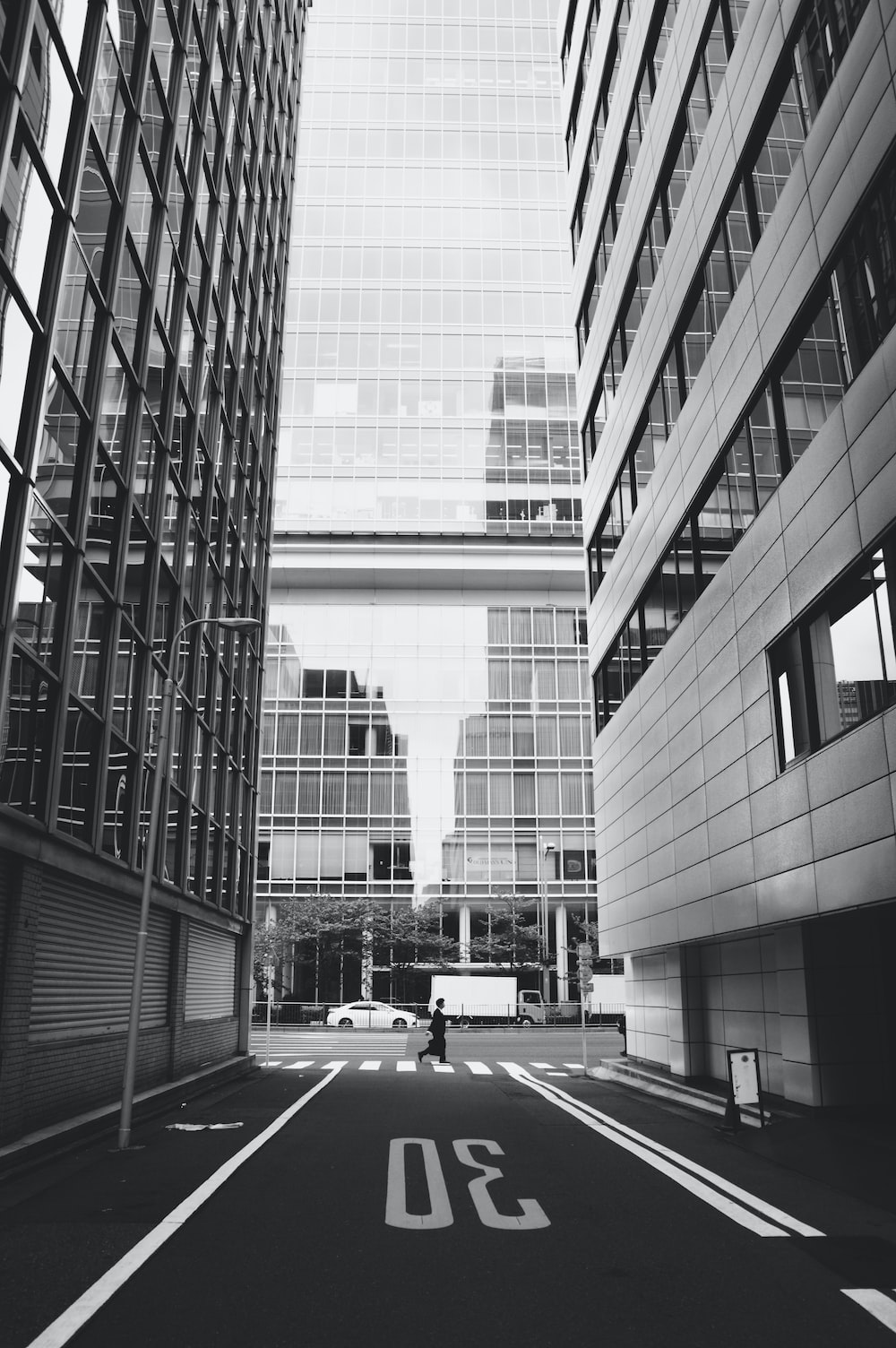 grayscale photo of cars on road near building photo