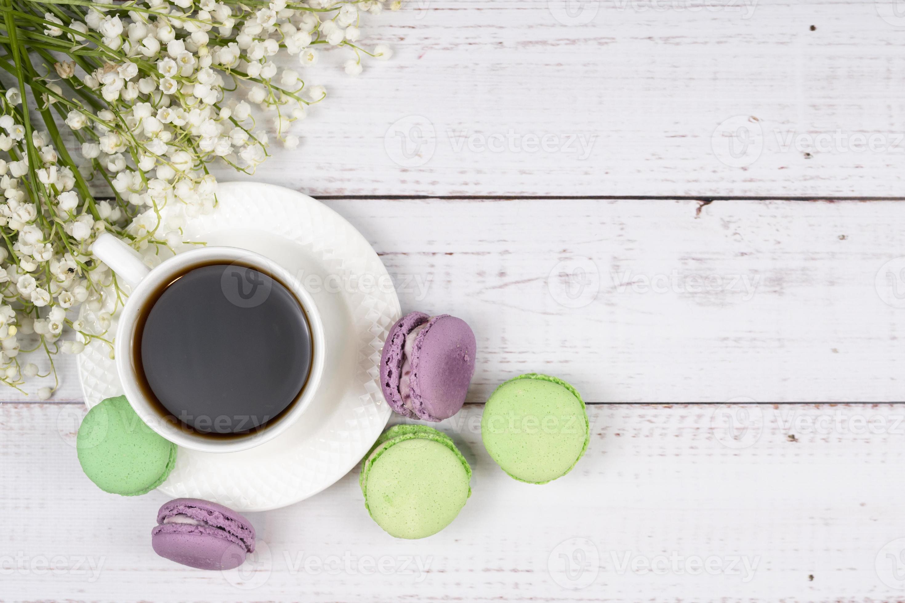Colorful Macaroons, A Cup Of Coffee And Lilies Of The Valley On Wooden Background, Close Up Flat Lay
