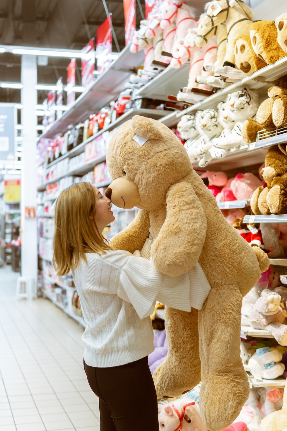 woman carrying life size bear plush toy photo