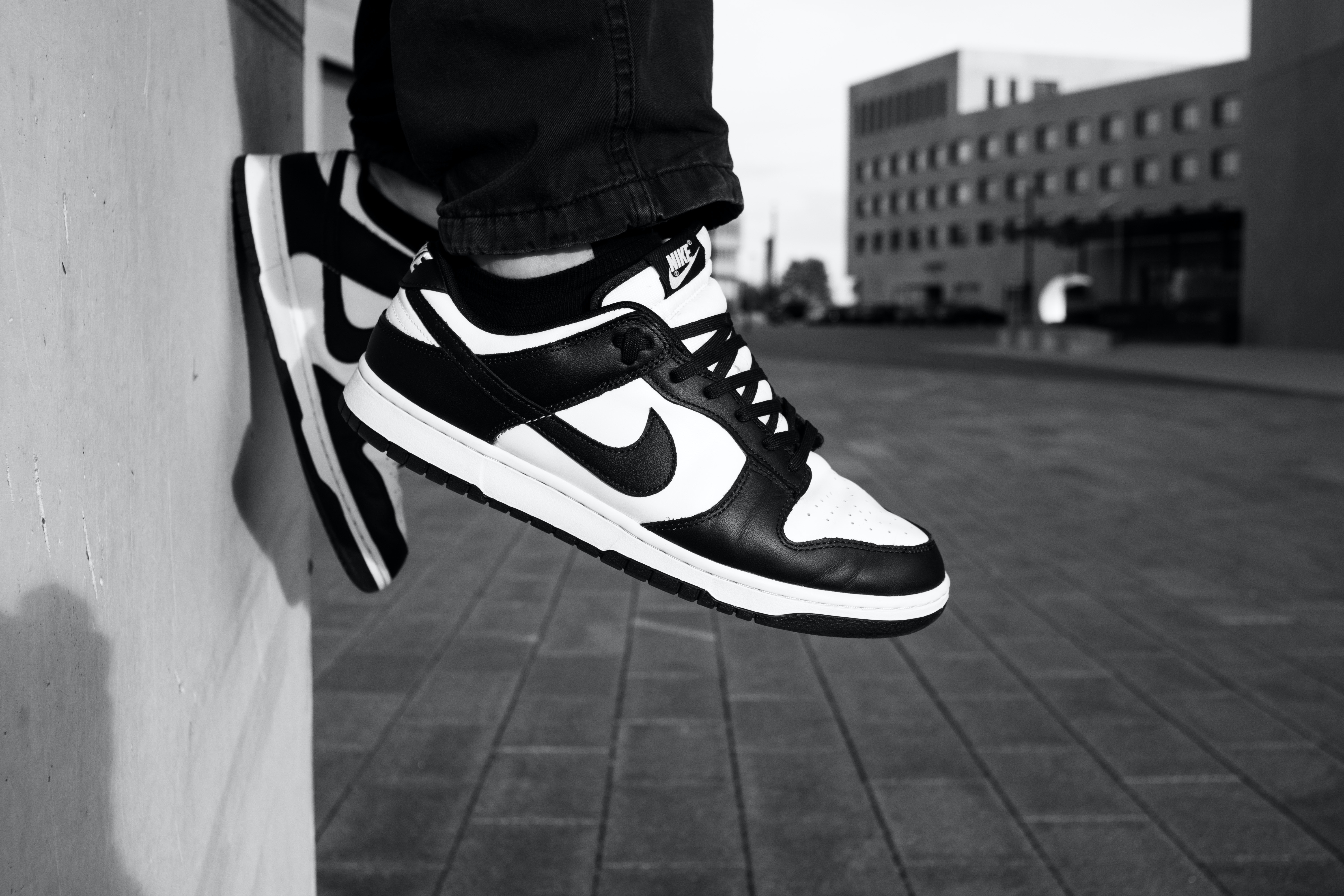 A Person Wearing Black and White Nike Sneakers · Free