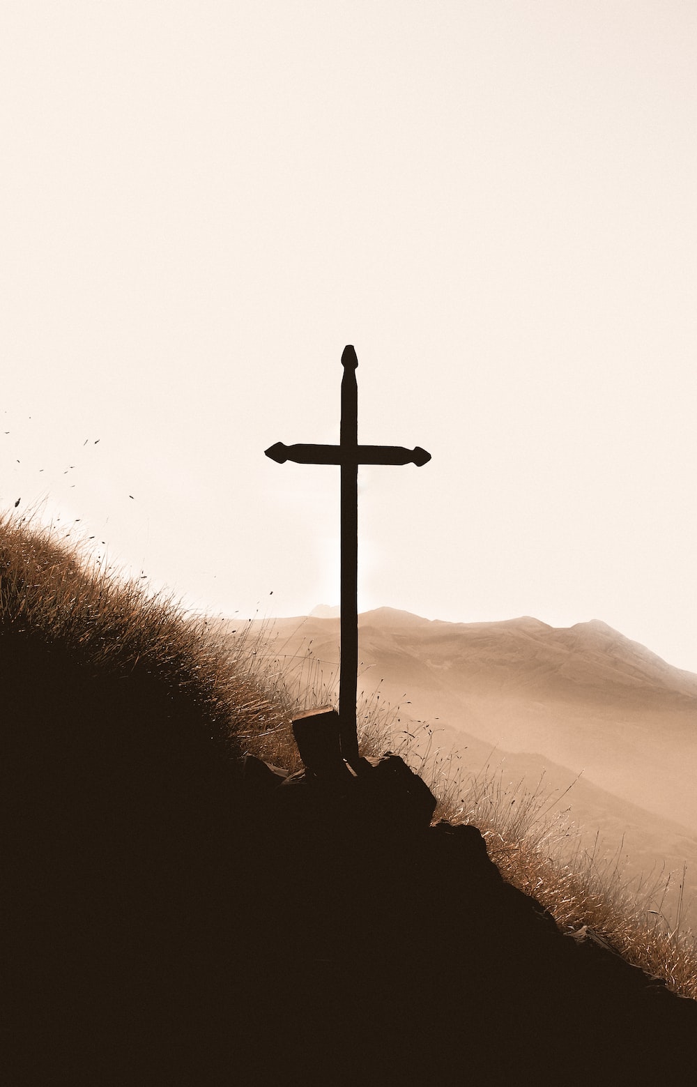 brown wooden cross on mountain during daytime photo
