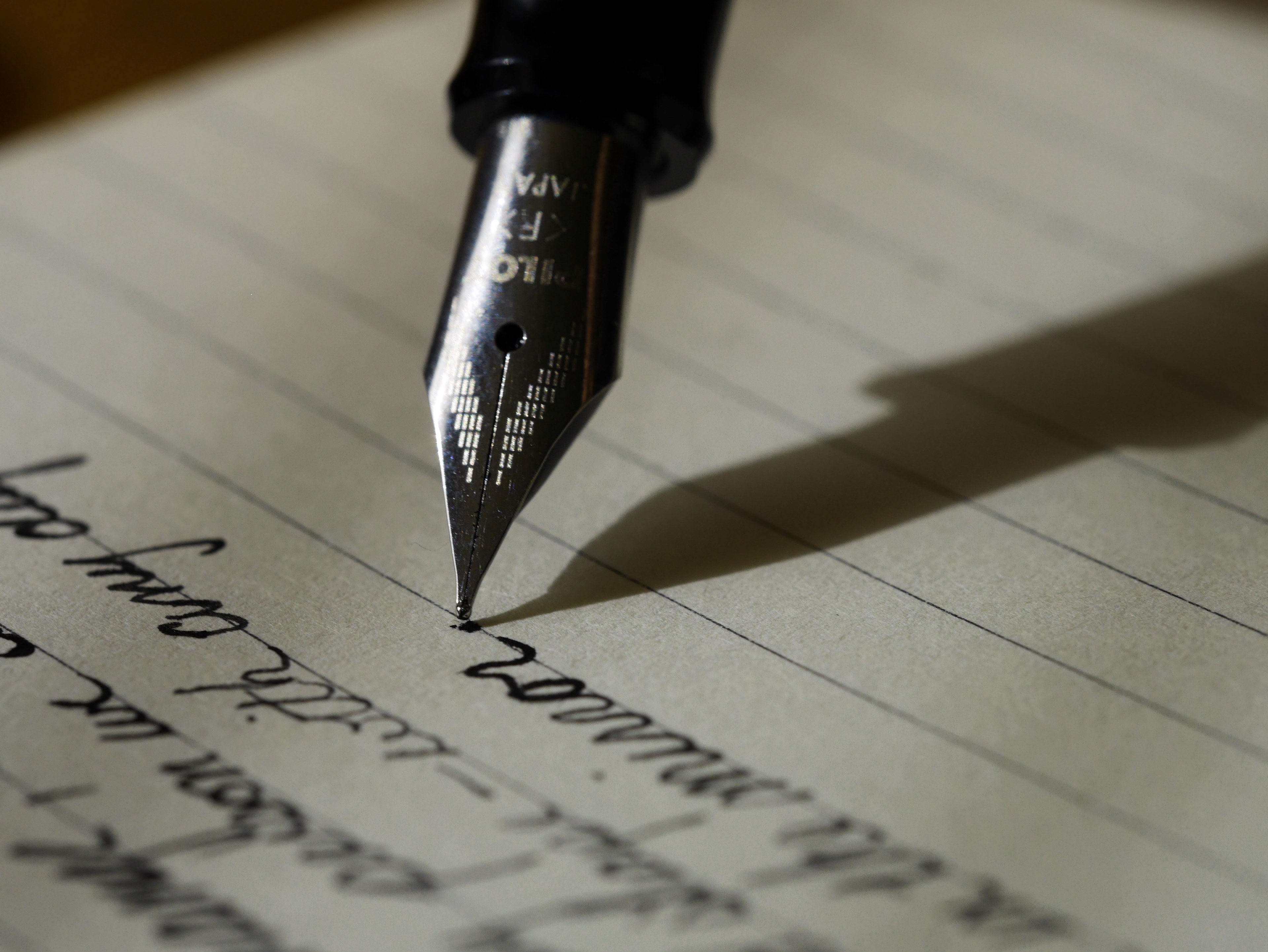 Wallpaper / close up of a fountain pen writing in a notebook, writing with a fountain pen 4k wallpaper free download