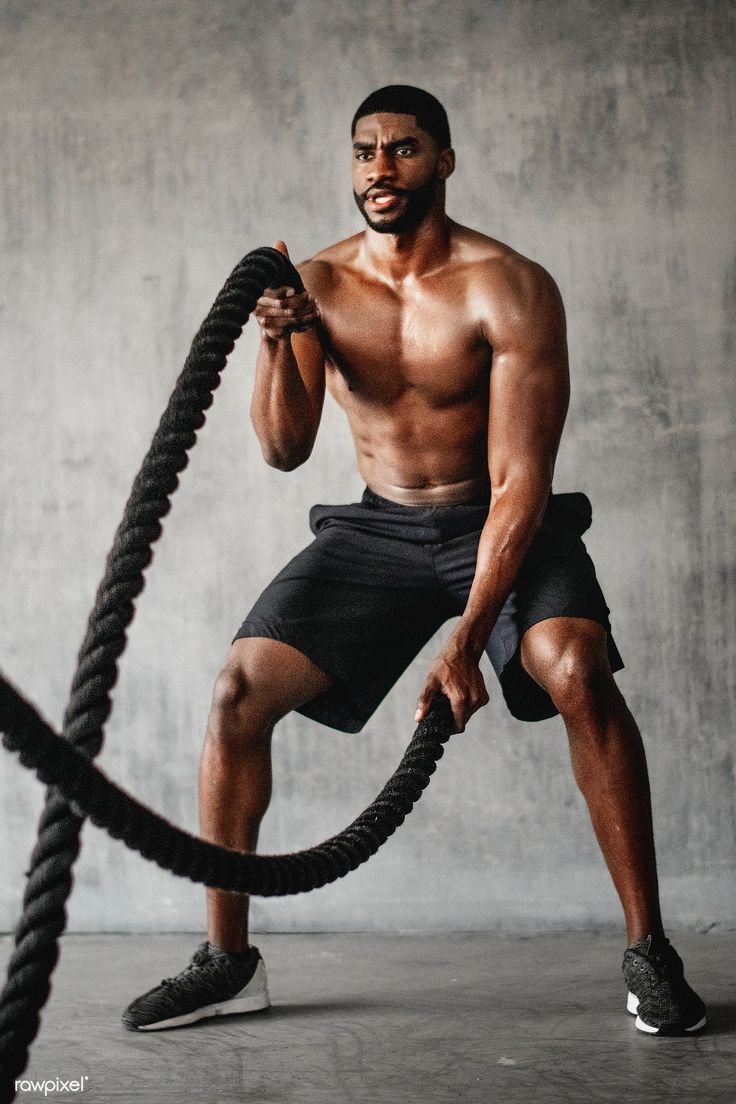 Muscular man working out on the battle ropes in a gym / Teddy Rawpixel. Male fitness photography, Gym photography, Gym photo