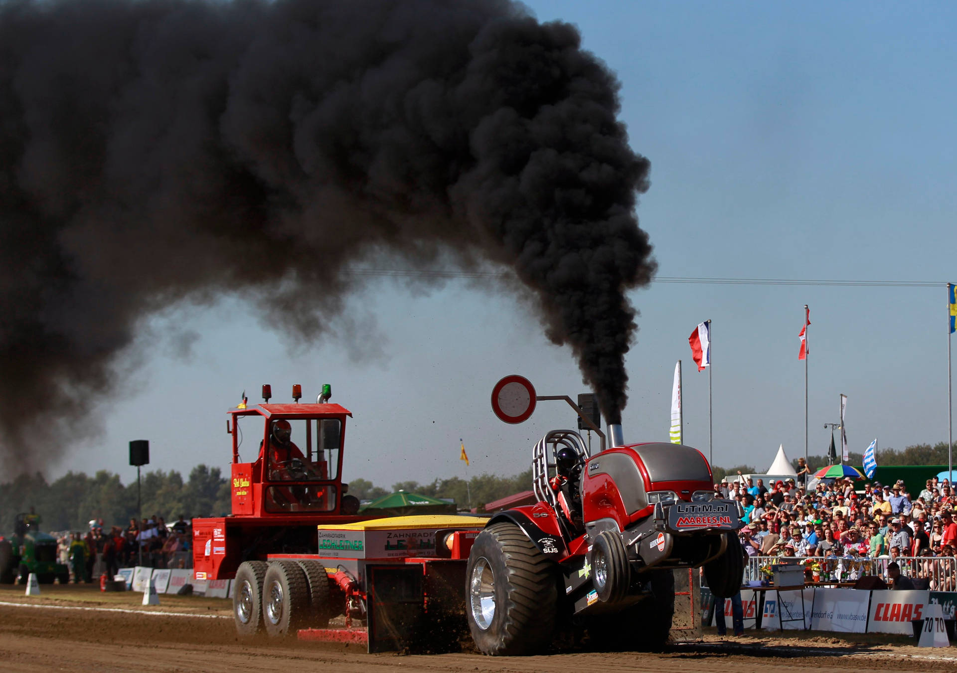 Download Red Pulling Tractor With Black Smoke Wallpaper