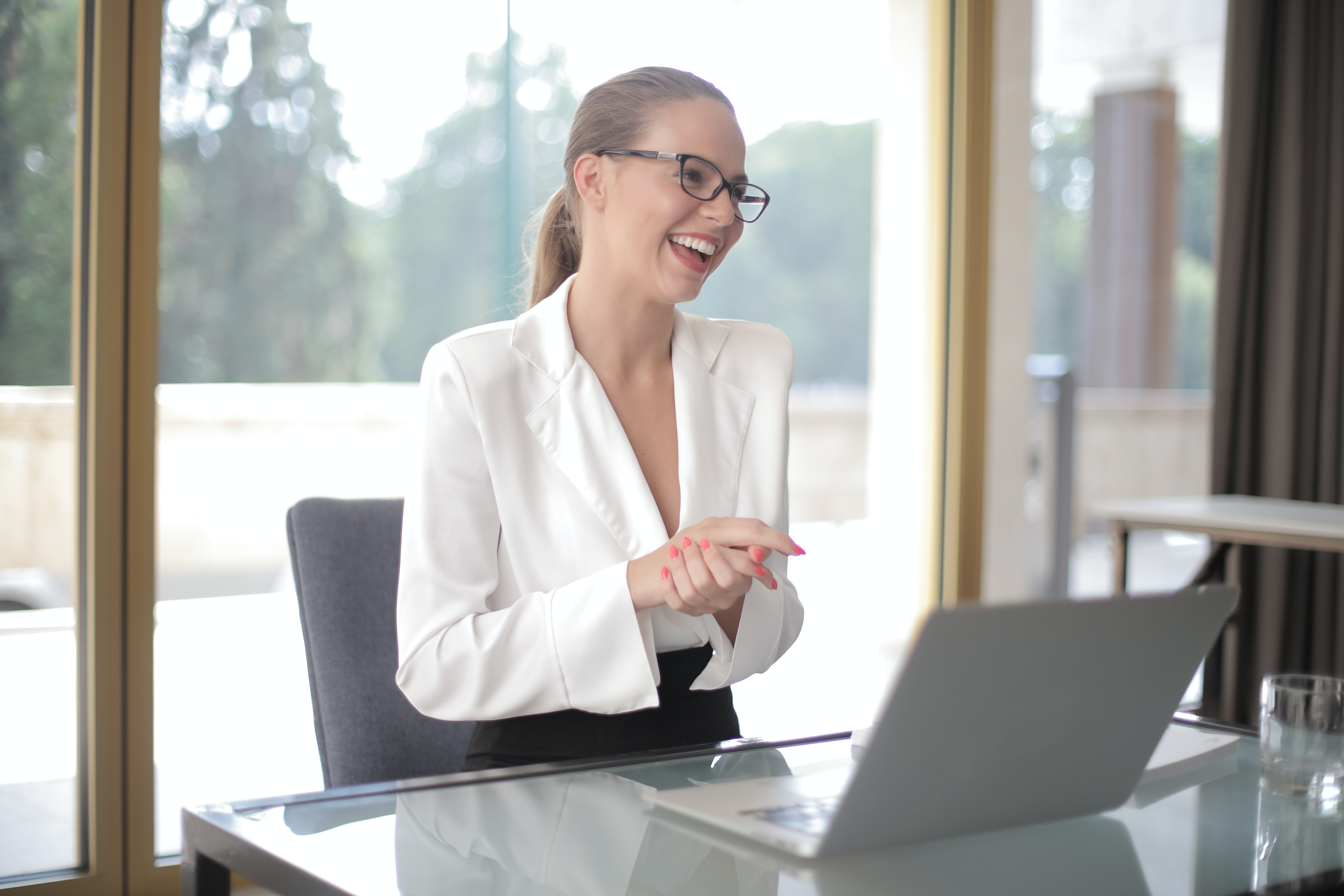 Smiling businesswoman with laptop in office · Free