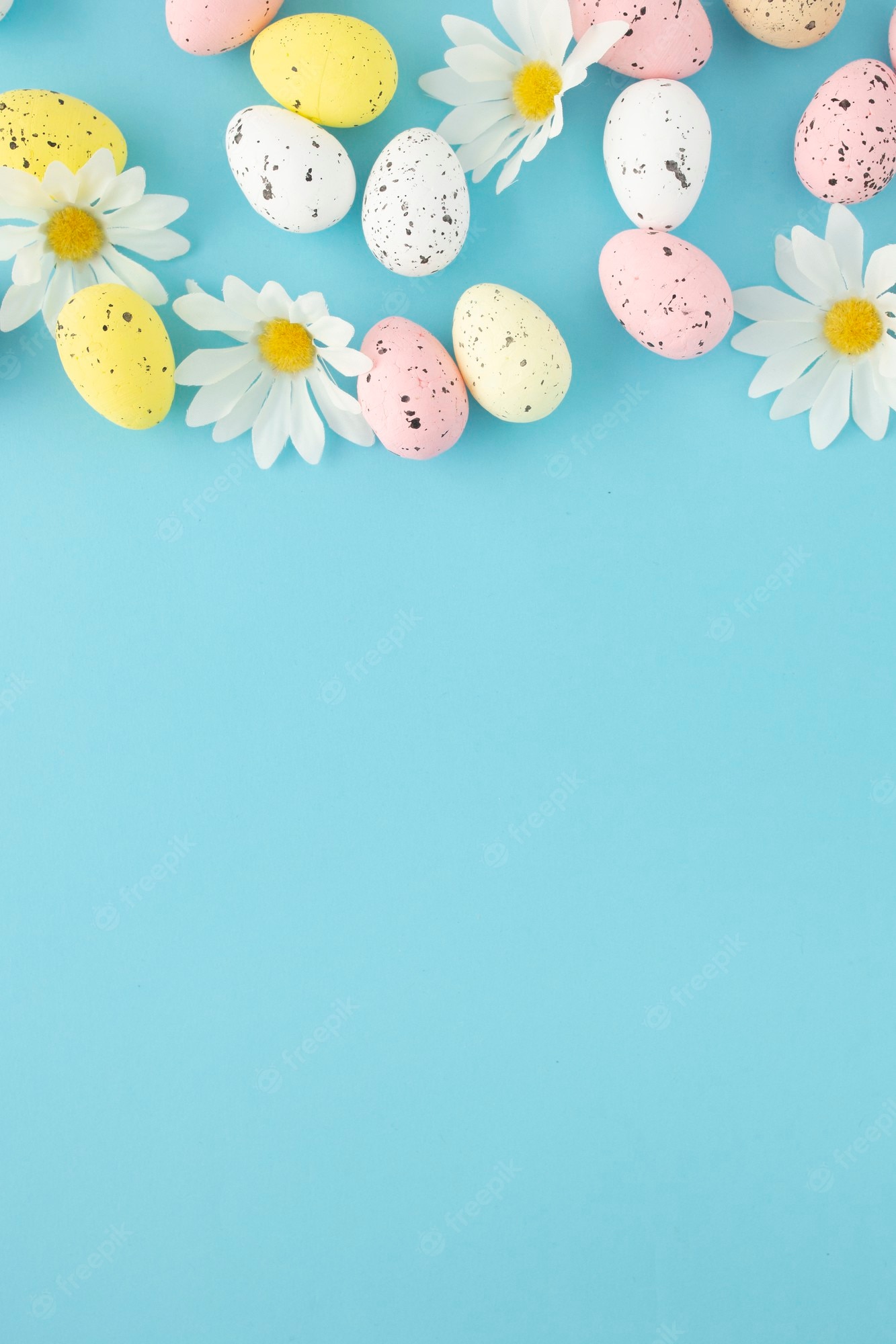 Free Photo. Easter invitation with eggs and daisies on a blue background with copy space