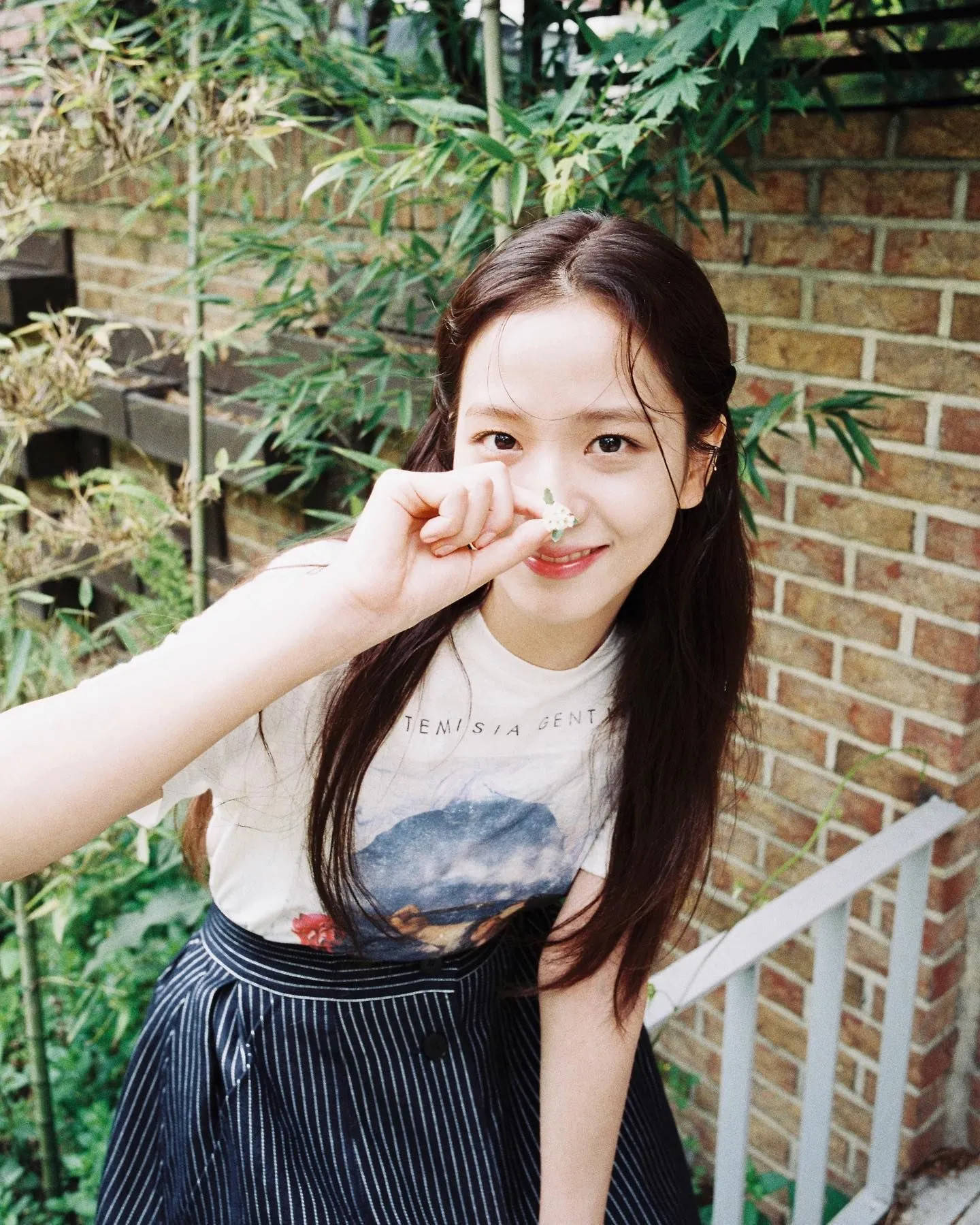 Download Jisoo Cute Holding Up A Flower Wallpaper