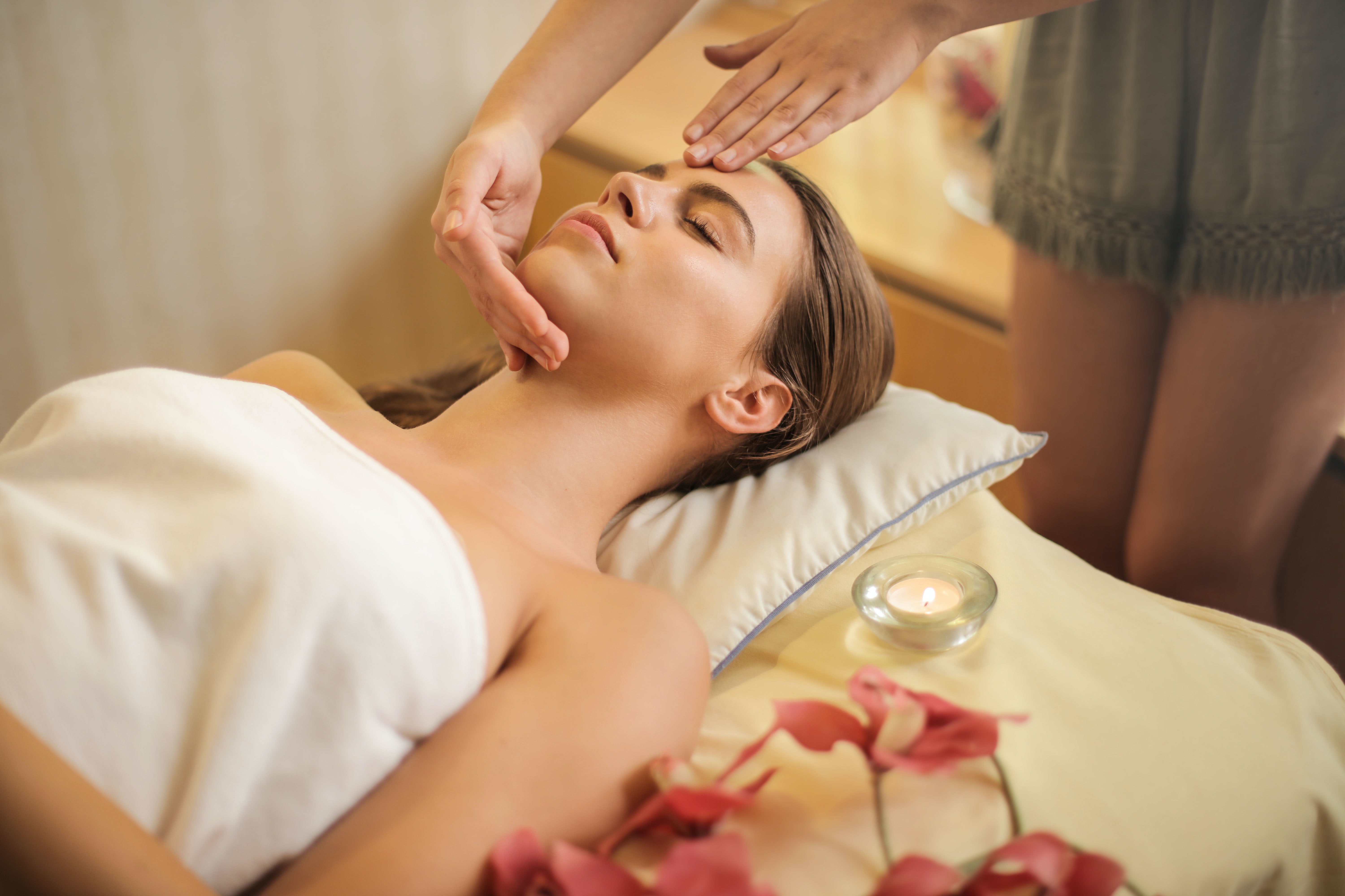 Woman in Wrapped in White Towel Lying on Bed Getting Massage · Free