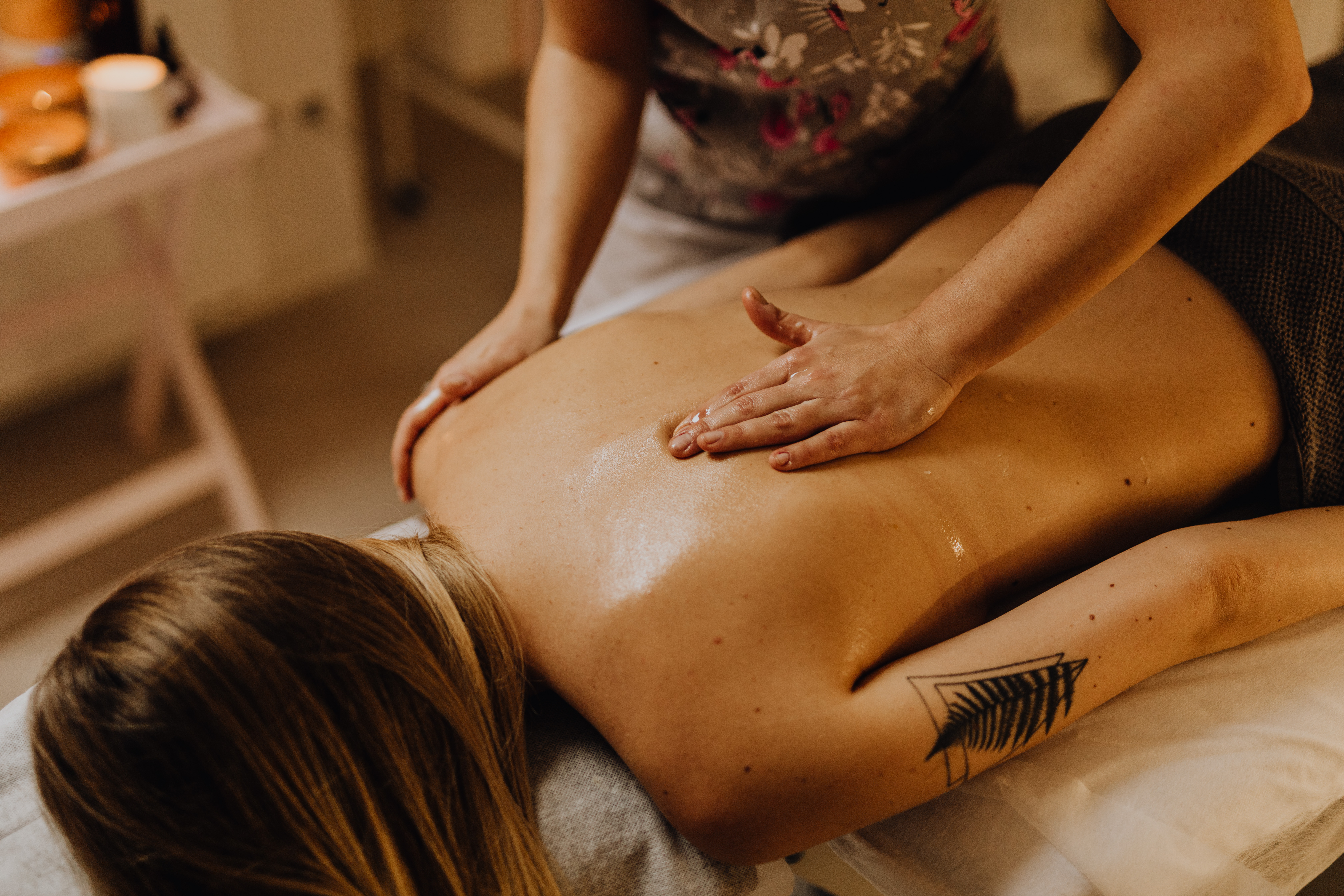 A Tattooed Woman Getting a Back Massage · Free