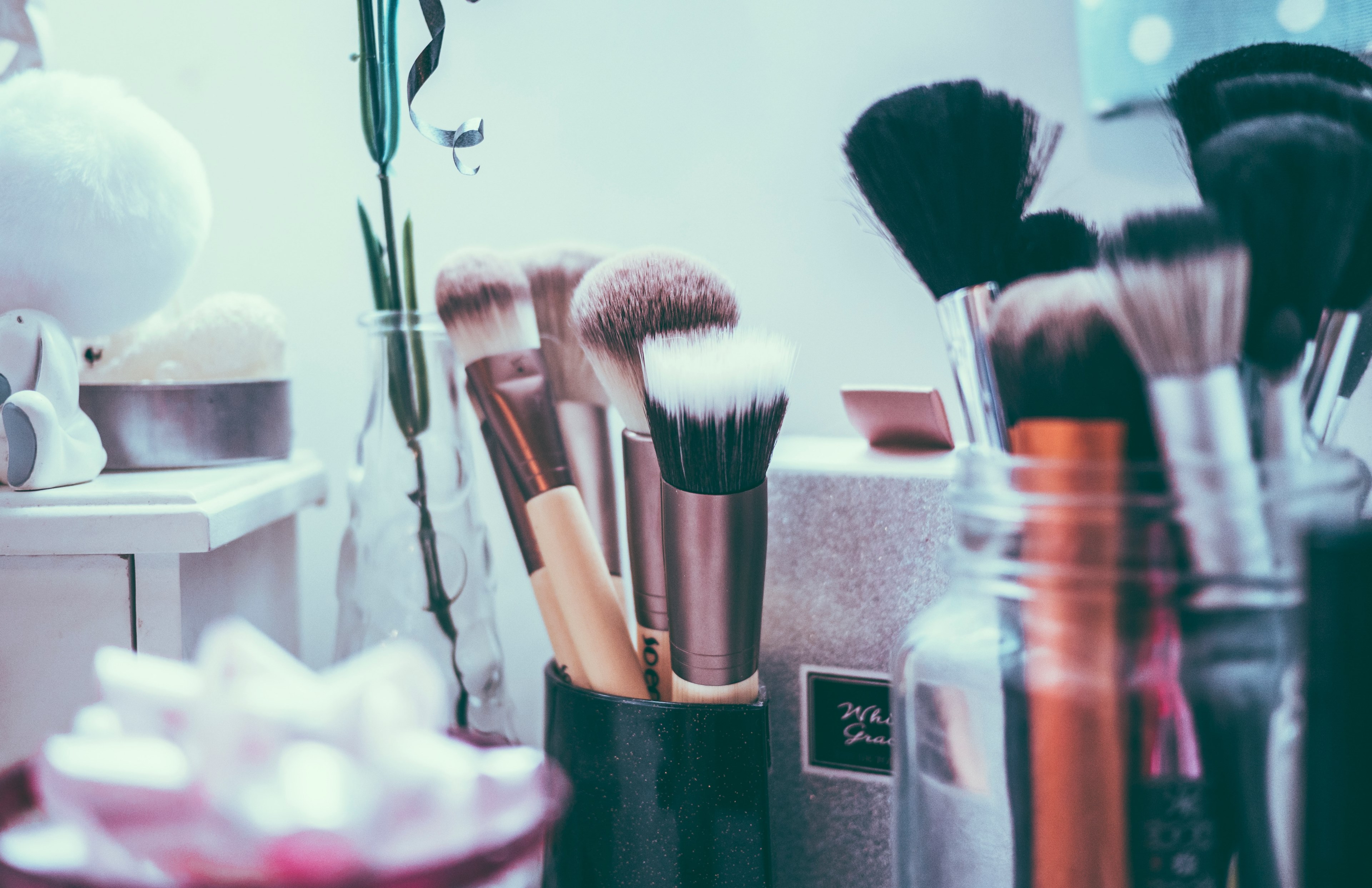 Wallpaper / a sparkly cup of makeup brushes surrounded my a vase with a plant and a jar of more makeup brushes, beauty salon brushes 4k wallpaper free download
