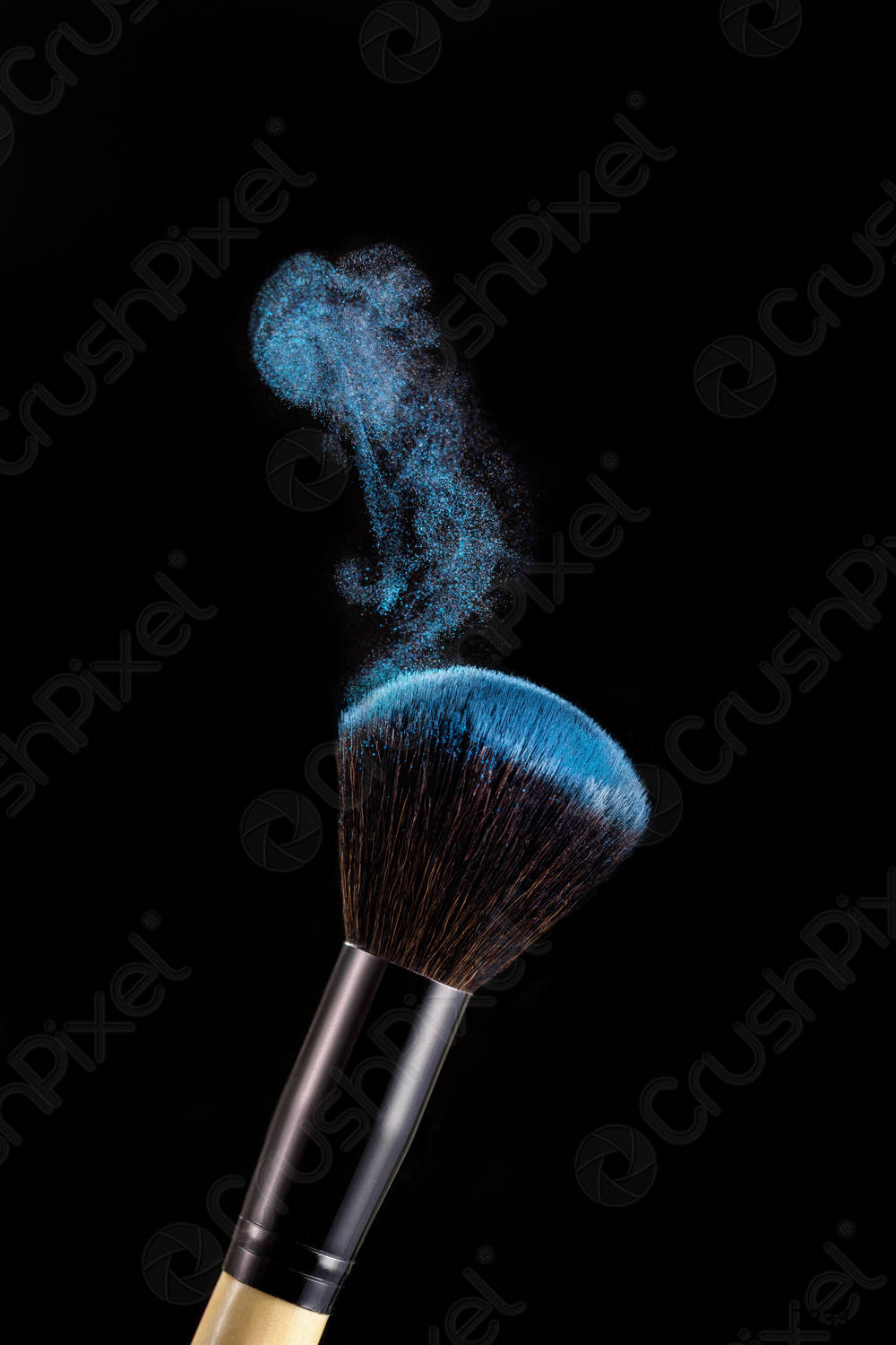Make up brush with powder splashes on black background