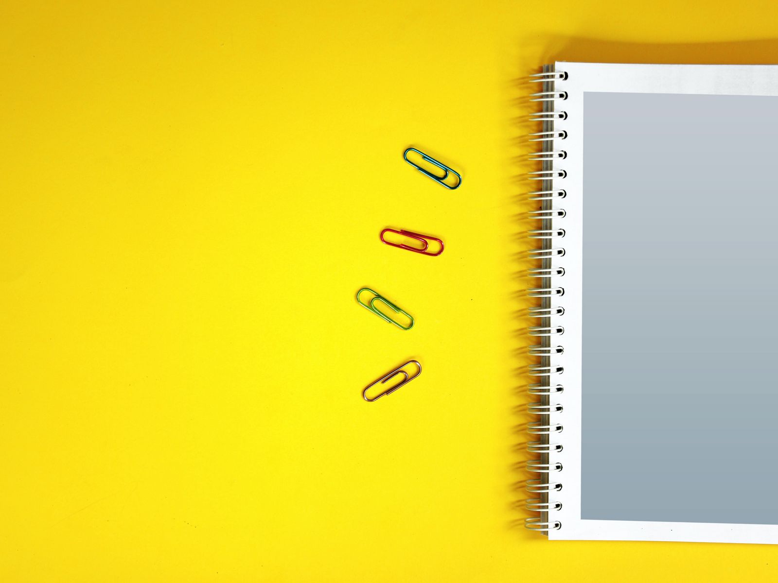 Download wallpaper 1600x1200 notebook, paper clips, surface, yellow standard 4:3 HD background