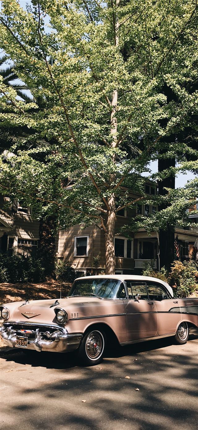 vintage pink sedan parked in front