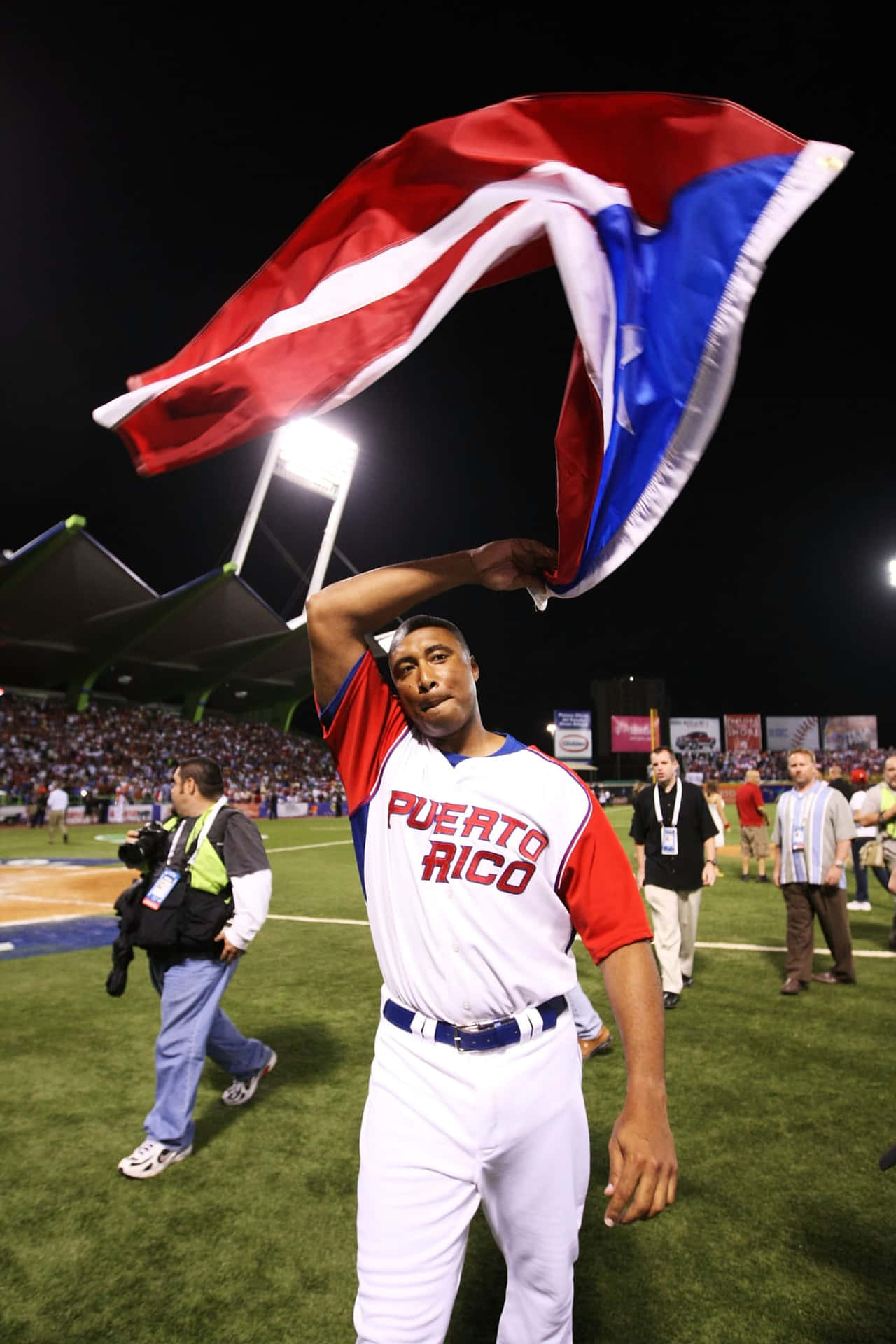 Download A Baseball Player Is Holding A Puerto Rican Flag Wallpaper