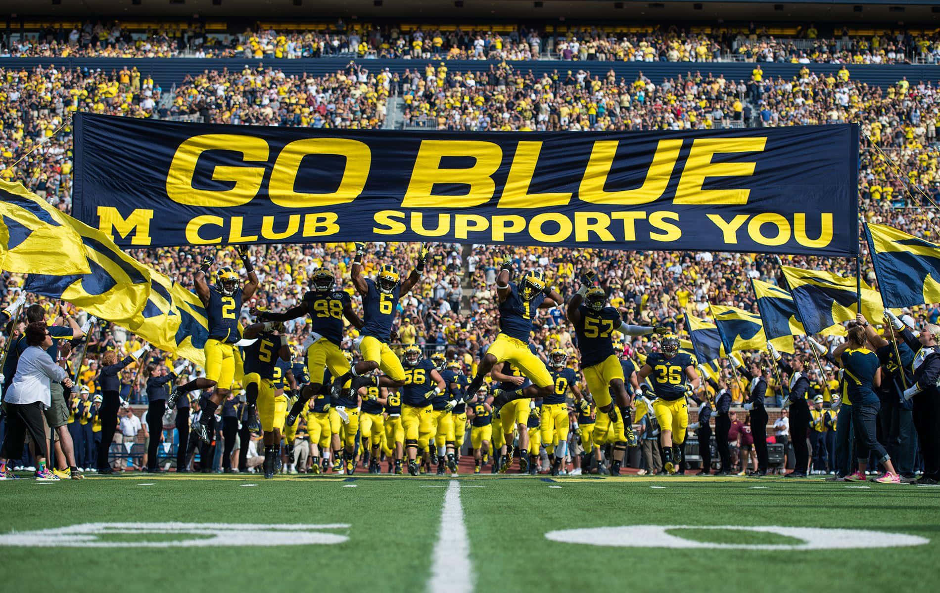 Download A Group Of People Holding A Banner That Says Go Blue Wallpaper