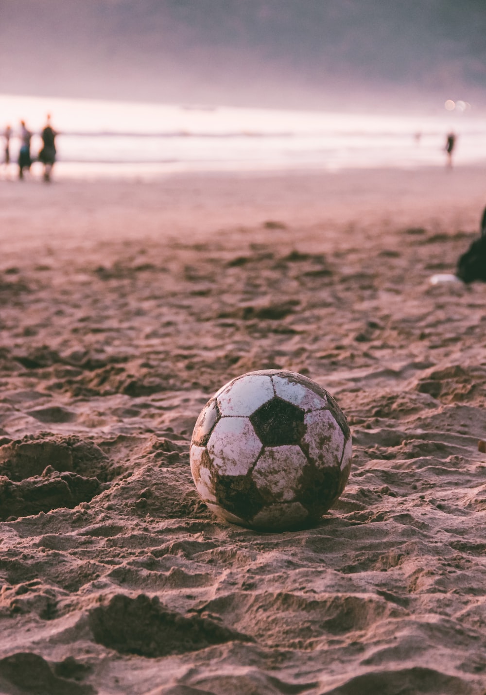 Black and white soccer ball on brown sand photo